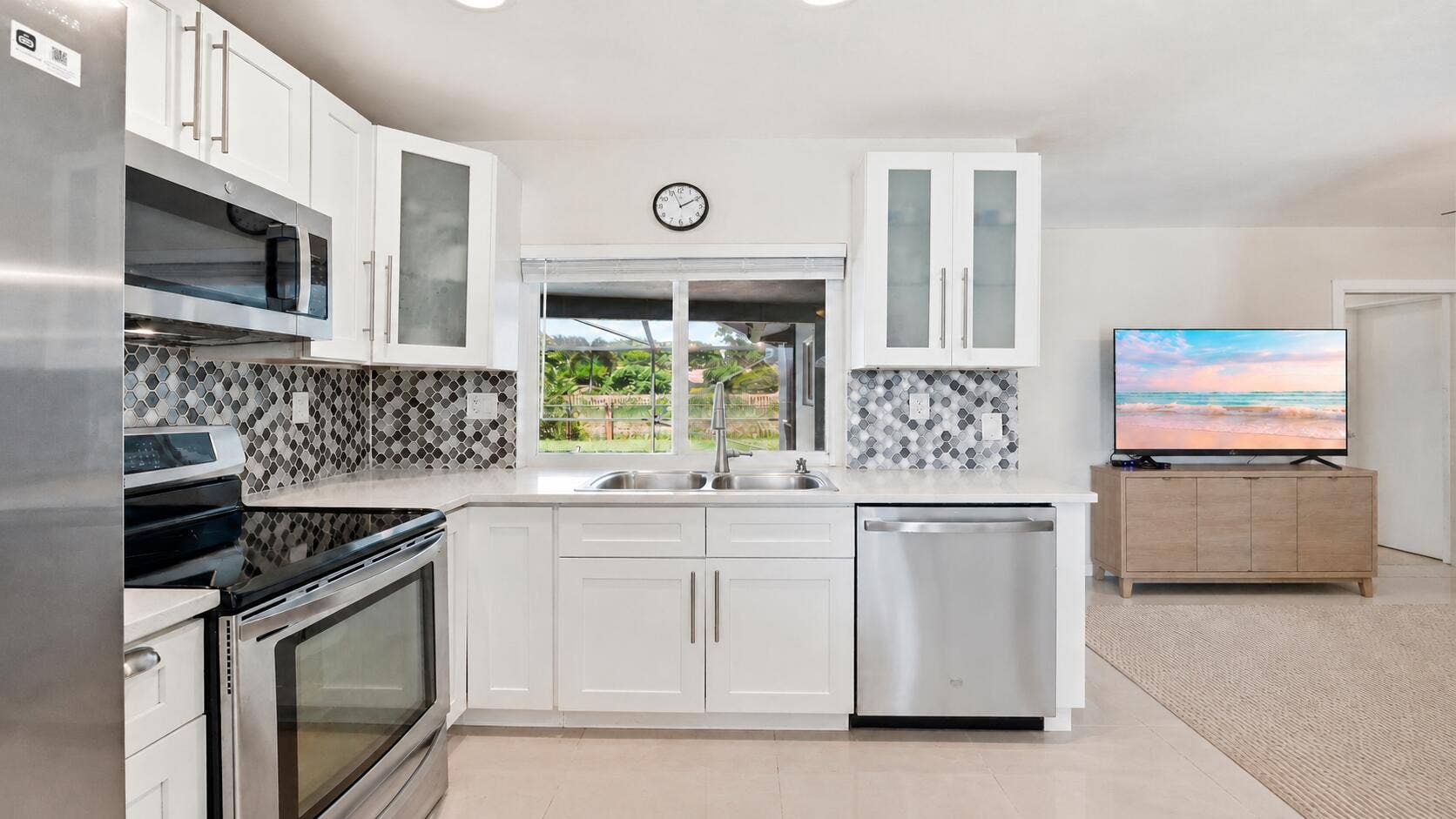 115 Orchard Ridge Lane, Boca Raton, FL 33431 Kitchen overlooking the pool and Family Room. (virtually staged for illustrative purposes; no permanent features or finishes have been altered)