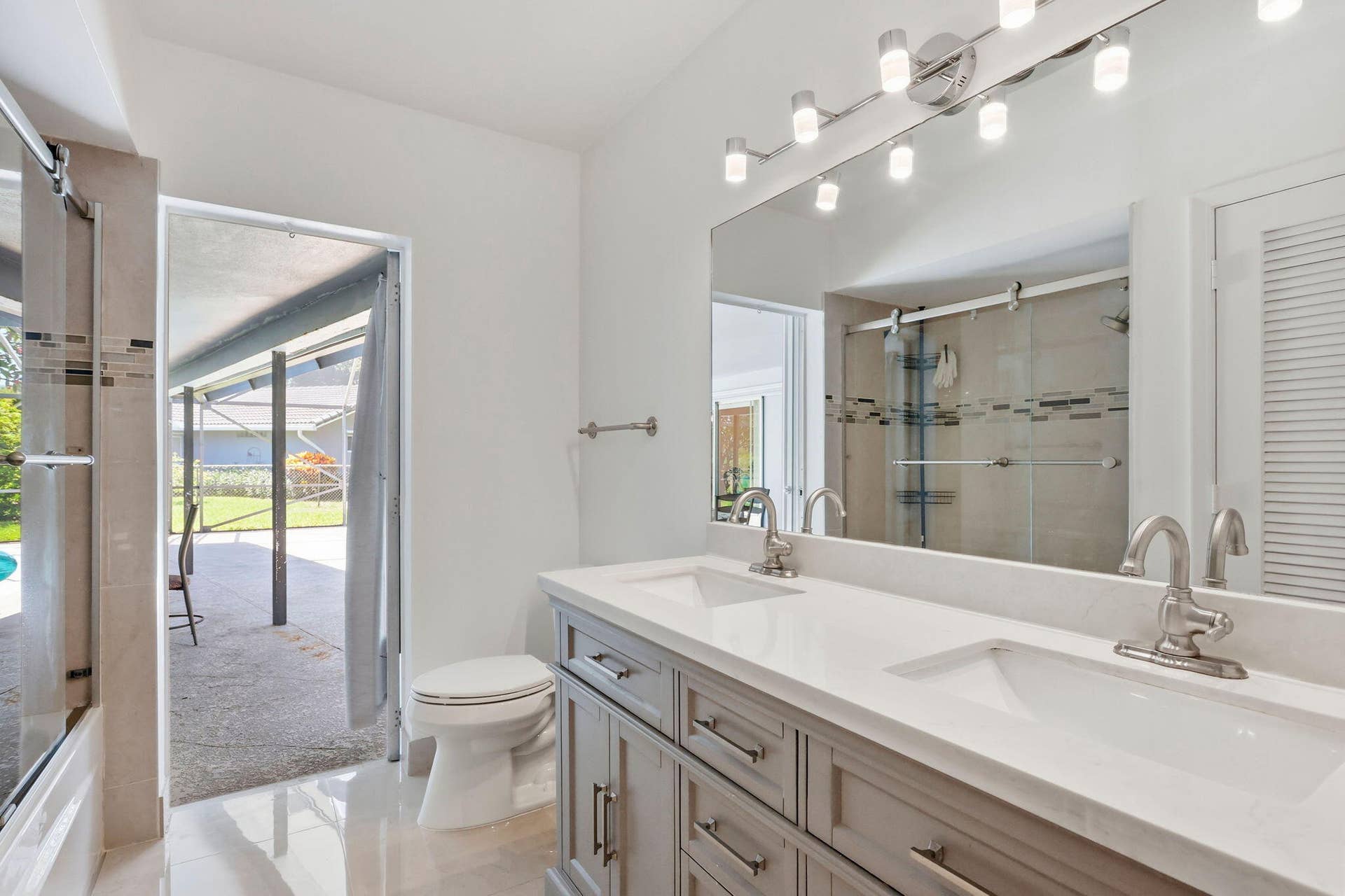 115 Orchard Ridge Lane, Boca Raton, FL 33431 cabana bathroom leads directly to patio/pool. (virtually staged for illustrative purposes; no permanent features or finishes have been altered)