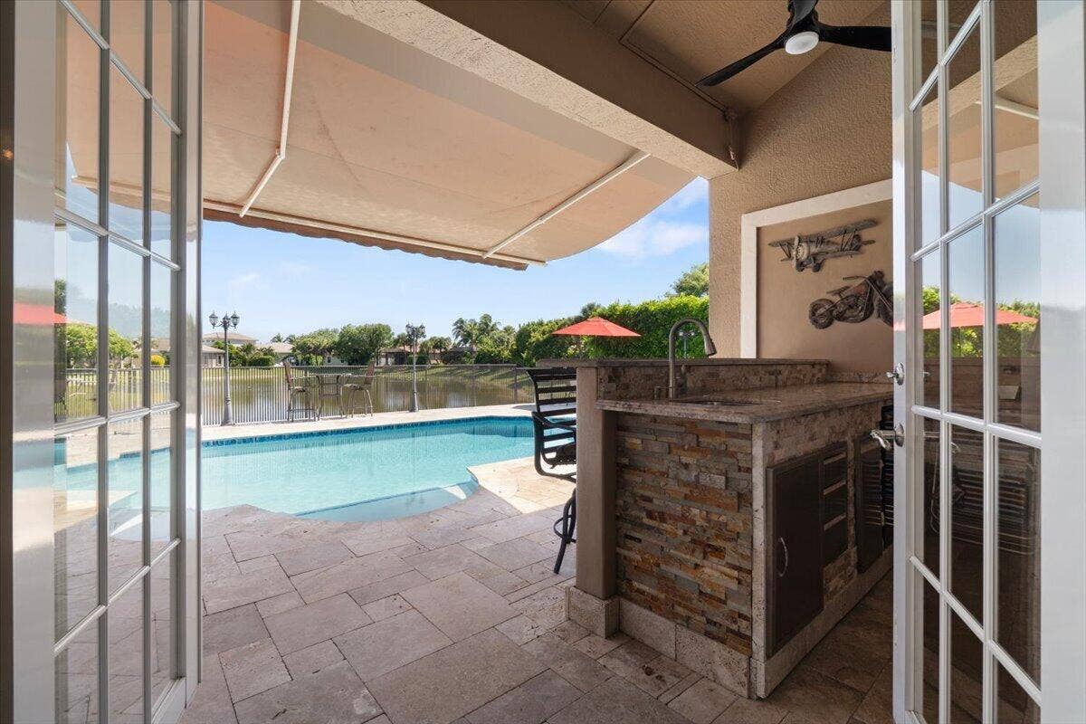 12390 NW 78th Manor, Parkland, FL 33076 Remote controlled retractable awning for keeping the shade while entertaining at the sports bar and TV, Cocktails anyone?