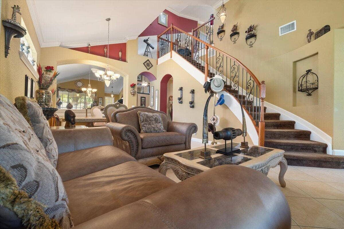 12390 NW 78th Manor, Parkland, FL 33076 The front living room is large and has a custom wrought iron staircase railing & varnished banister built with solid wood varnish, Italian tile throughout, Leather couches and high end immaculate furniture included, Interior recently painted,