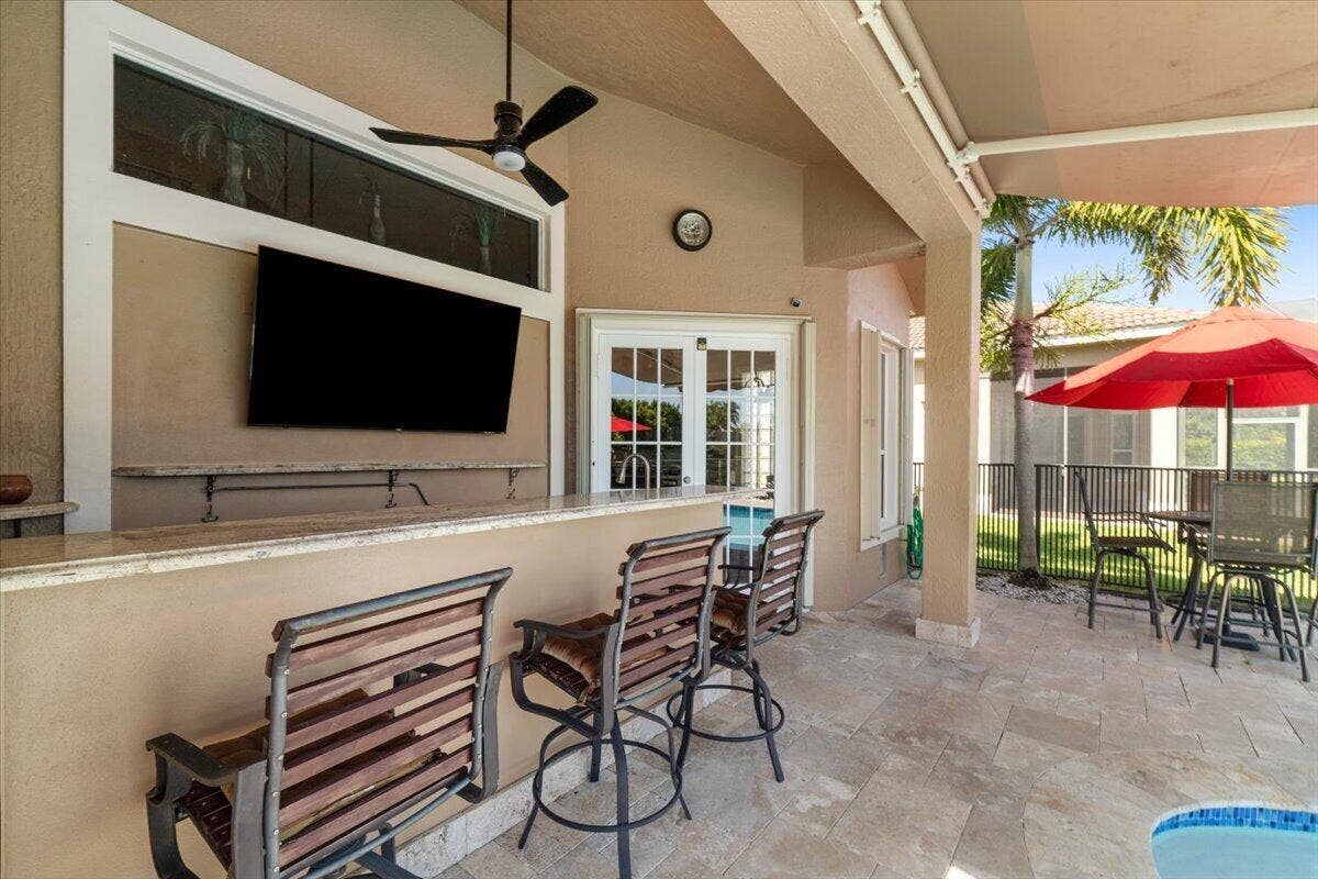 12390 NW 78th Manor, Parkland, FL 33076 The outside bar area TV is also included and great for watching the game while grilling or having a beer of cocktail at the bar, Bar stools included as well as all pretty patio furniture as seen