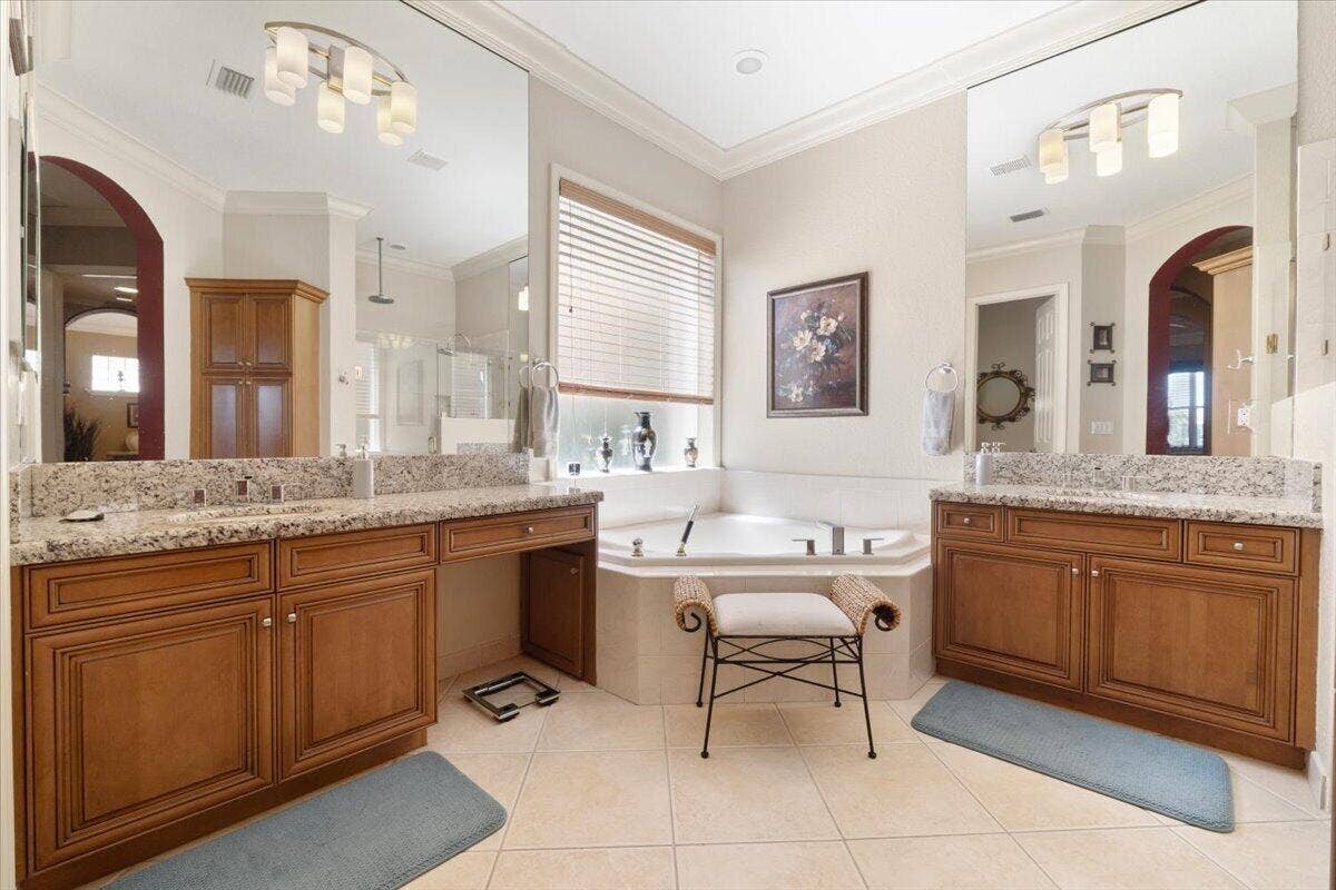 12390 NW 78th Manor, Parkland, FL 33076 The master bathroom suite has double vanities and a water closet with a separate bidet with warm water,high mirrors & cherry cabinets, a real hot tub with a heater to keep you warm in your relaxing bubble bath, (portrait on wall not included with sale of house, sentimental value)