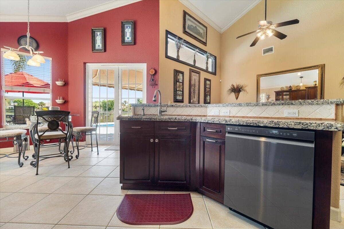 12390 NW 78th Manor, Parkland, FL 33076 Facing the kitchen Island into the family room, Top of the line hardware features on the sink and faucets throughout, Real Wooden cabinets with soft close doors, Spectacular granite countercops,
