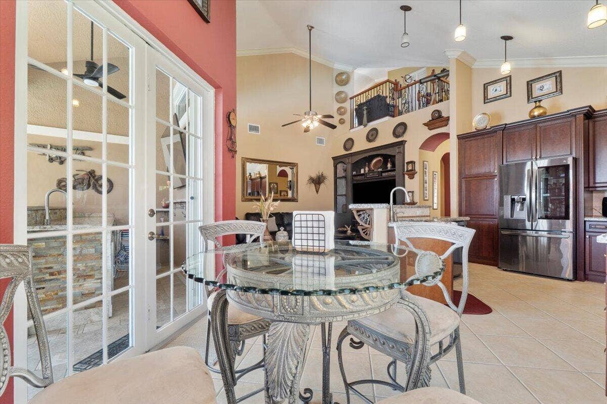 12390 NW 78th Manor, Parkland, FL 33076 A view from the French Bistro dining table to the family room and beyond! Behind this chair on the left is a built in little doggie or kitty door to go outside
