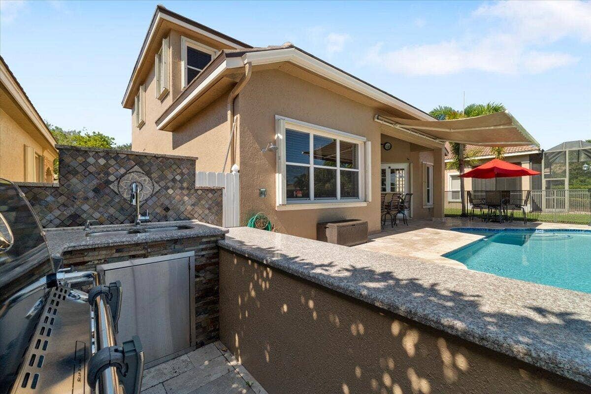 12390 NW 78th Manor, Parkland, FL 33076 Summer kitchen BBQ with everything needed for grilling! Sit at the counter end enjoy Cheeseburgers or steaks & hotdogs for the kids