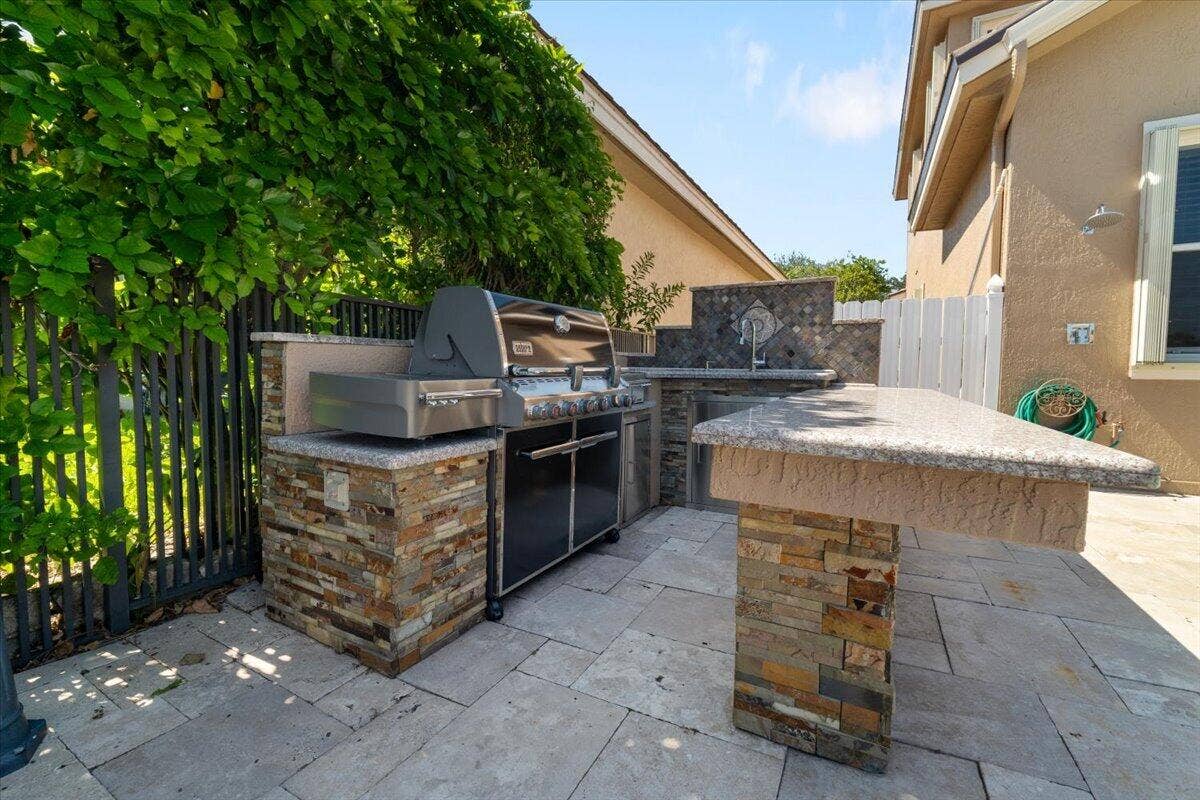 12390 NW 78th Manor, Parkland, FL 33076 This stone custom summer kitchen with built in BBQ & sink and fridge
