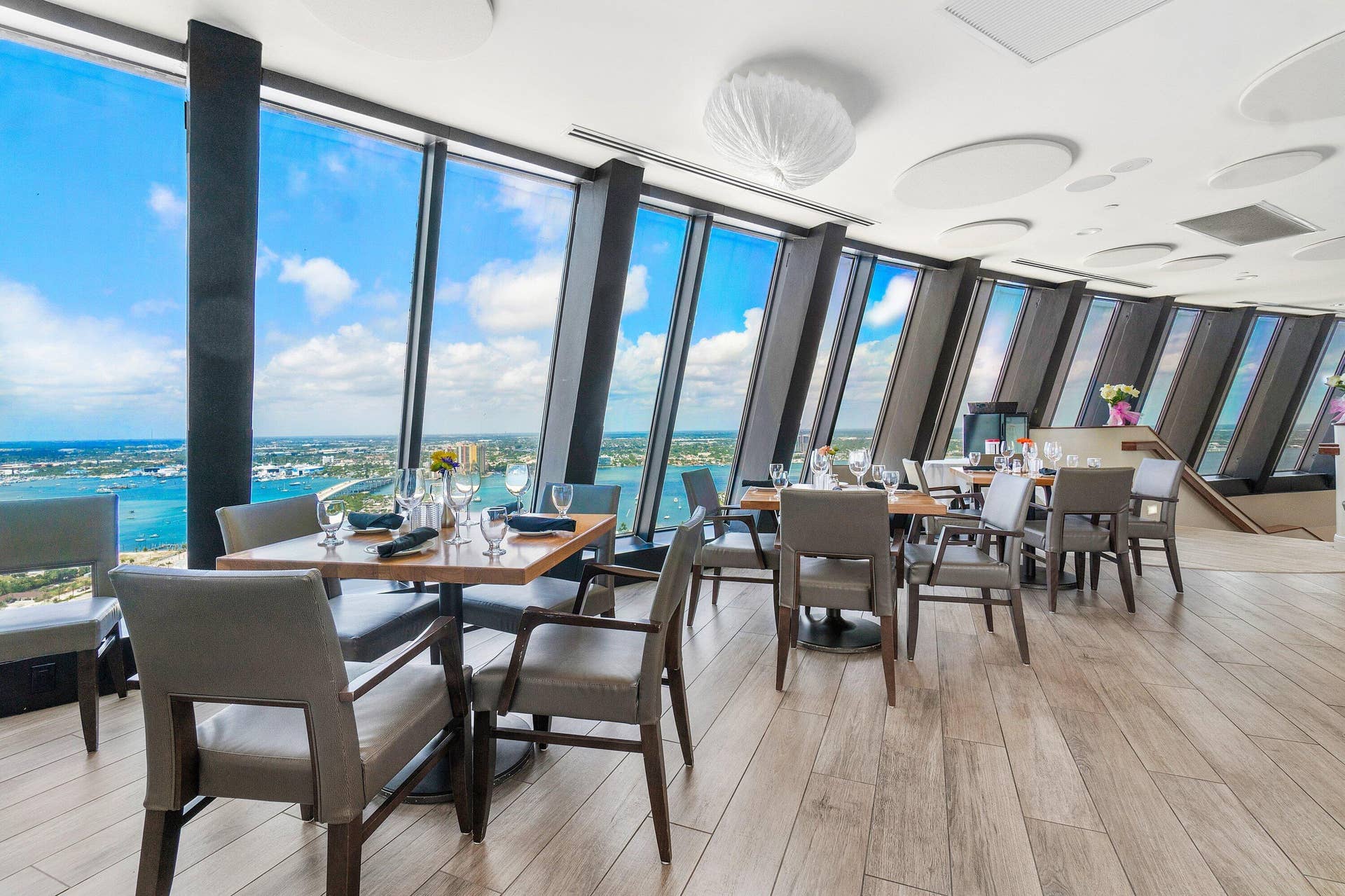 Dining tables line expansive windows overlooking the Atlantic Ocean in one of Tiara's restaurant spaces.