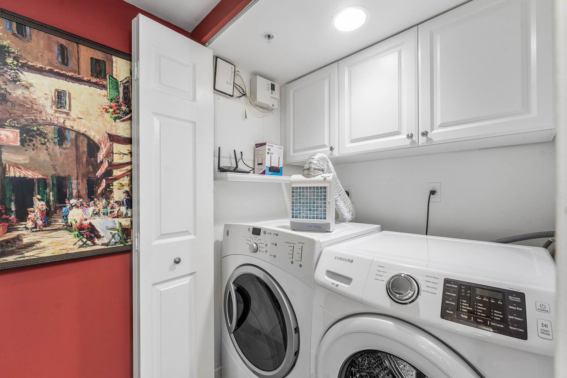 The interior laundry area includes a full-size washer and dryer with upper cabinetry for additional storage.