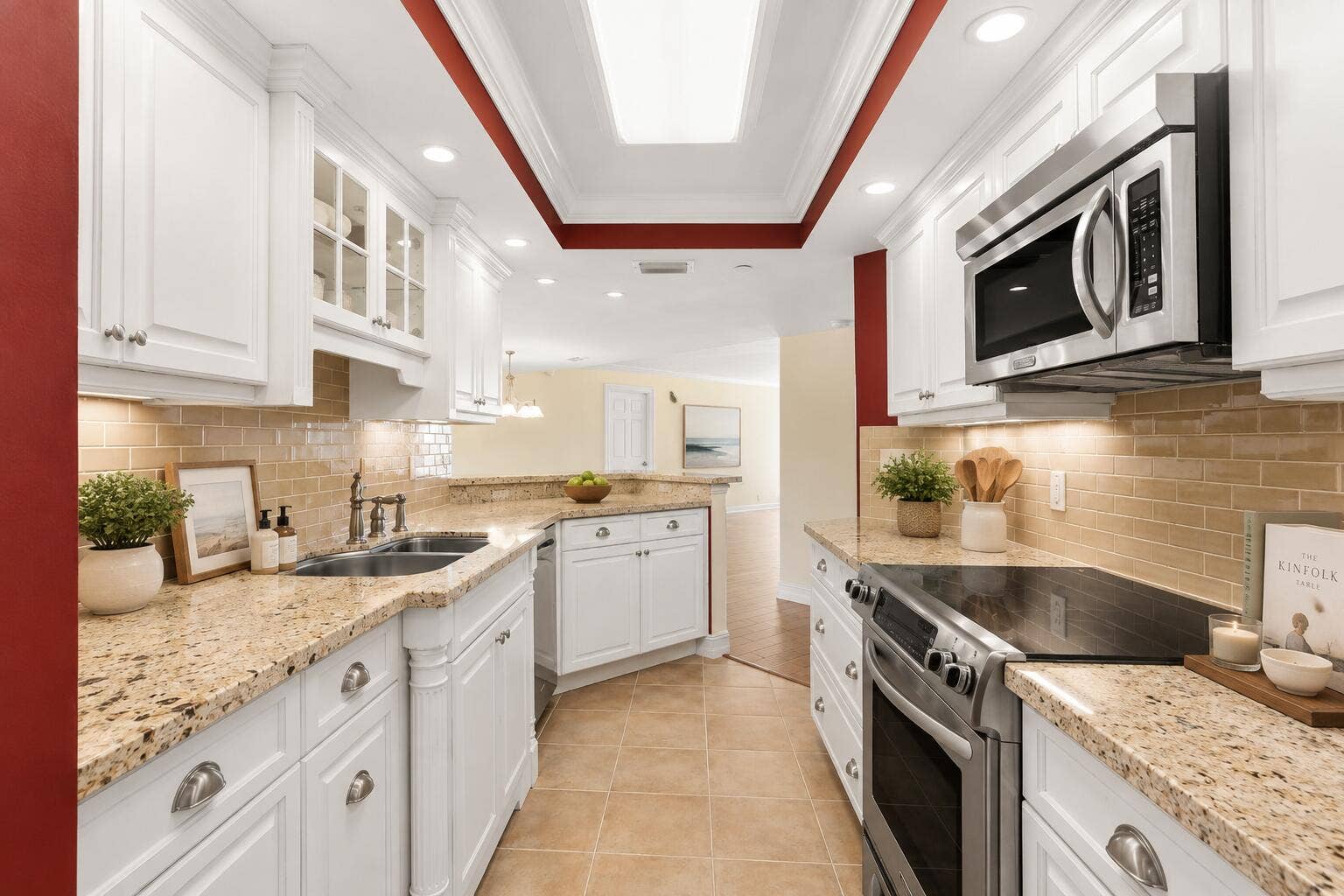 The kitchen combines granite countertops, white cabinetry, tiled backsplash and stainless-finish appliances with generous prep and storage space.