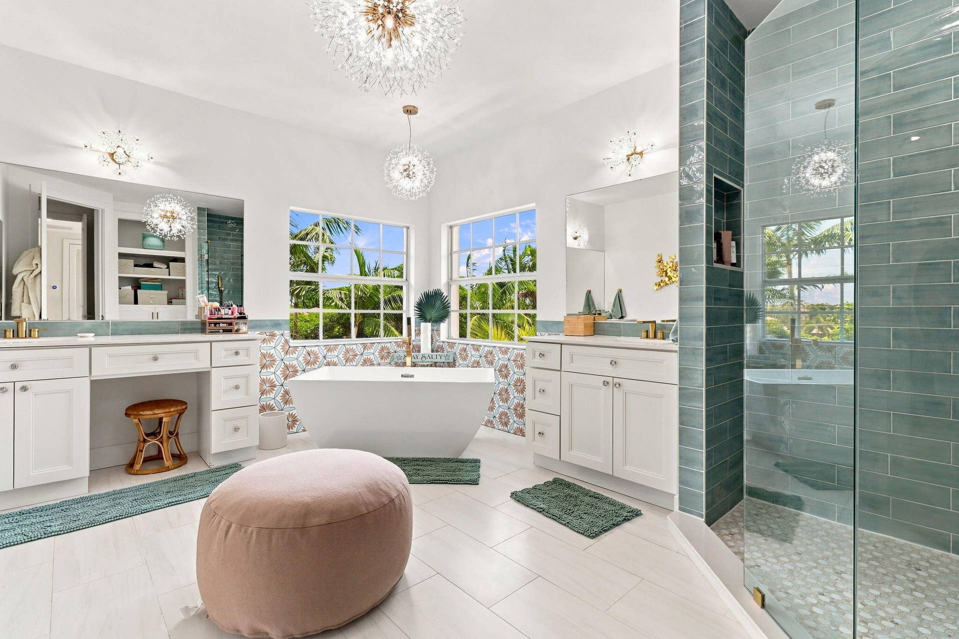 Freestanding soaking tub, dual vanity with white cabinetry, glass-enclosed shower with subway tile, white tiled flooring and multiple windows