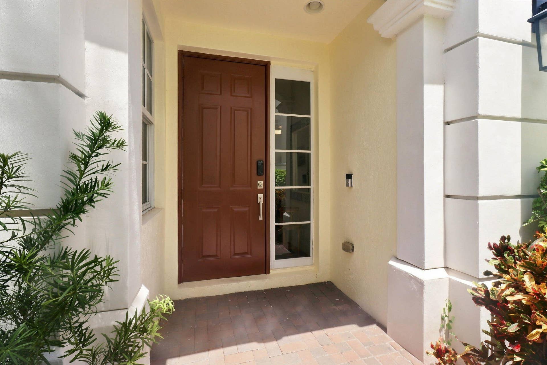 Entryway featuring a paneled wood door, sidelight and textured exterior walls