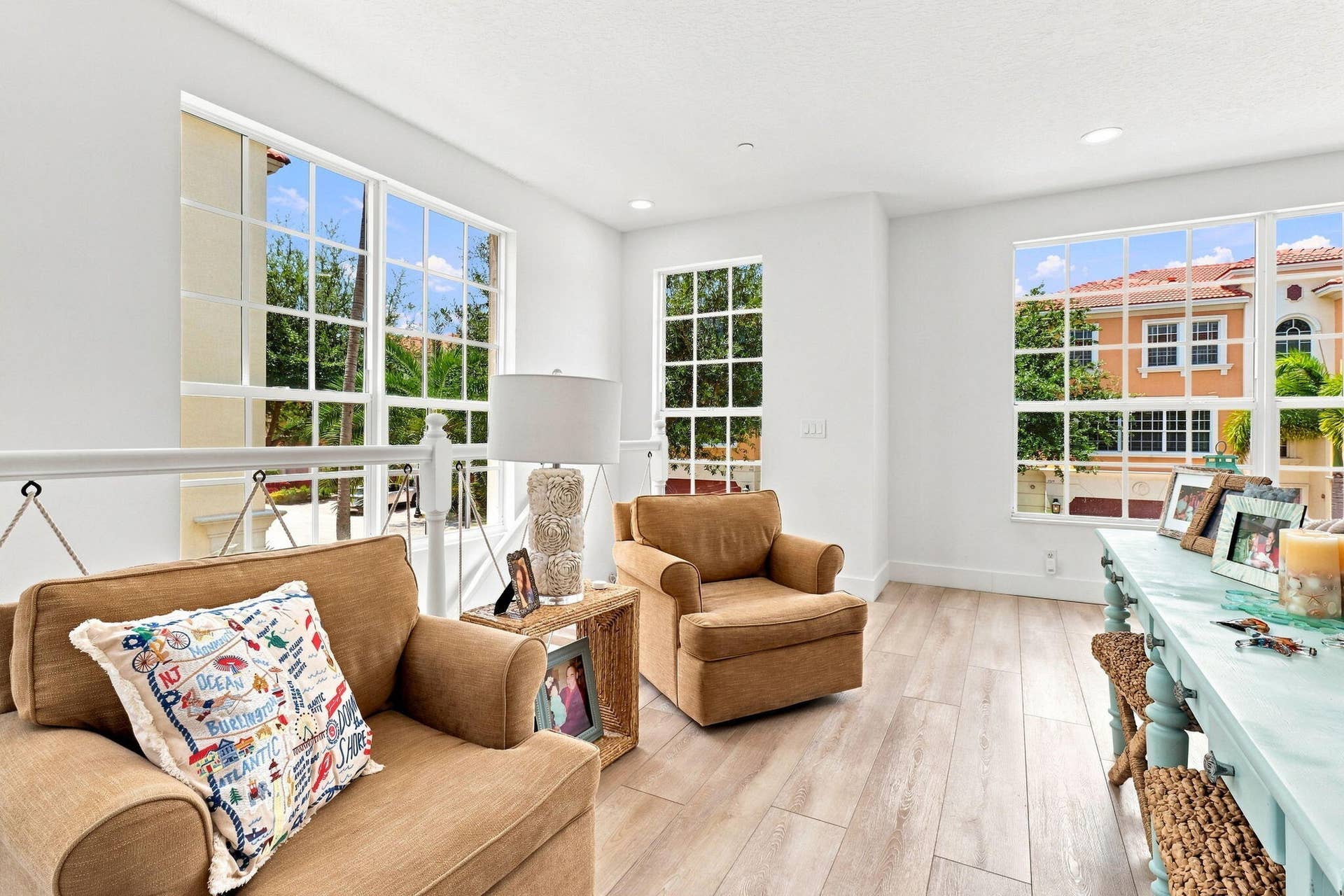 Recessed lighting, luxury vinyl flooring, bright walls, multiple large windows with grid patterns and a nautical interior railing