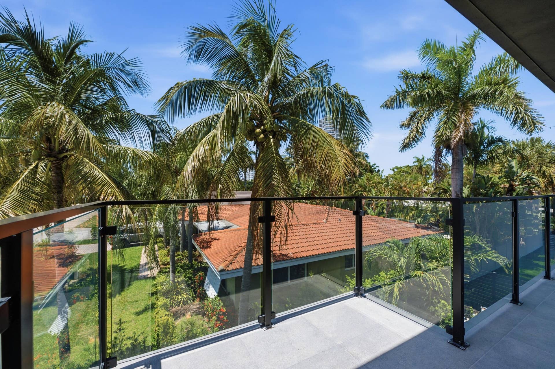 Balcony featuring a glass railing system and tile flooring