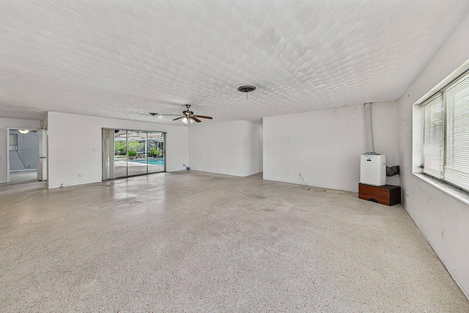 201 NE 29th Street, Wilton Manors, FL 33334 Generously proportioned living space with terrazzo flooring and direct access to the screened pool area.