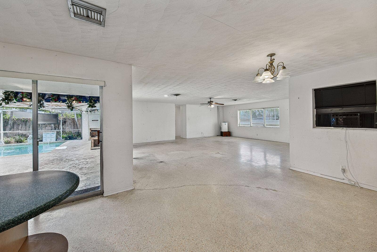 201 NE 29th Street, Wilton Manors, FL 33334 Broad interior view demonstrates the homes spacious layout and connection to the pool area.