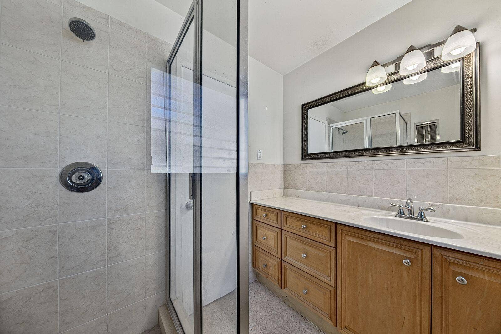 201 NE 29th Street, Wilton Manors, FL 33334 Bathroom features a tiled glass-enclosed shower, substantial vanity storage and generous counter space.