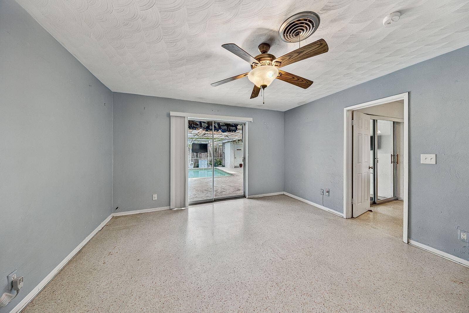 201 NE 29th Street, Wilton Manors, FL 33334 Comfortable bedroom with terrazzo flooring, an adjoining bathroom and direct access to the pool.
