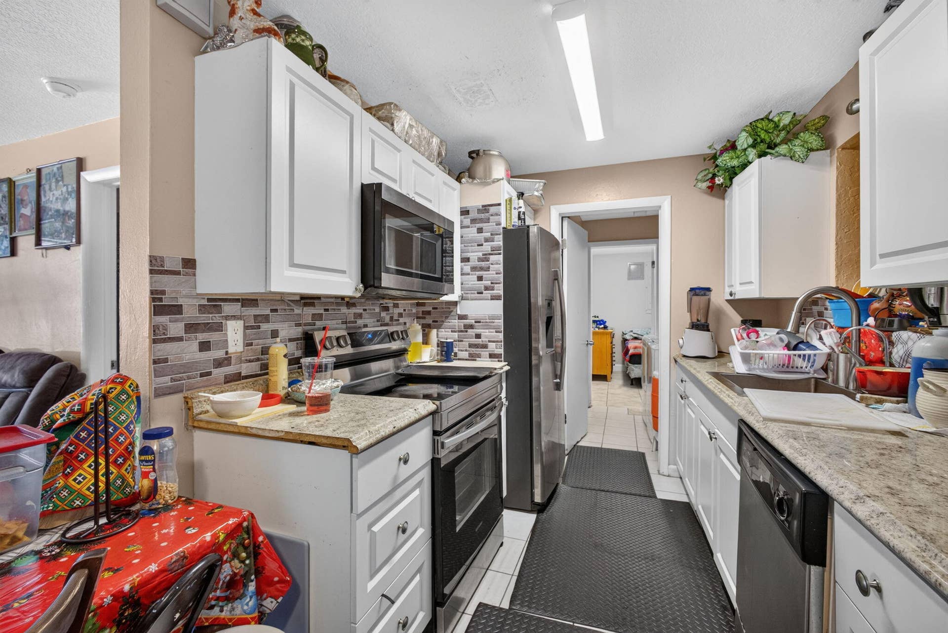 Expansive backyard featuring artificial turf, a screened-in patio, and a dedicated utility shed