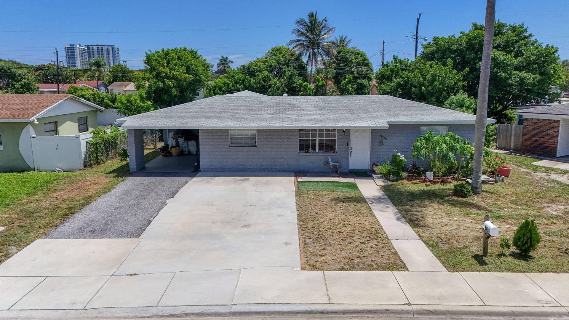 Single-story residence featuring a shingle roof, carport, concrete driveway, and a paved walkway