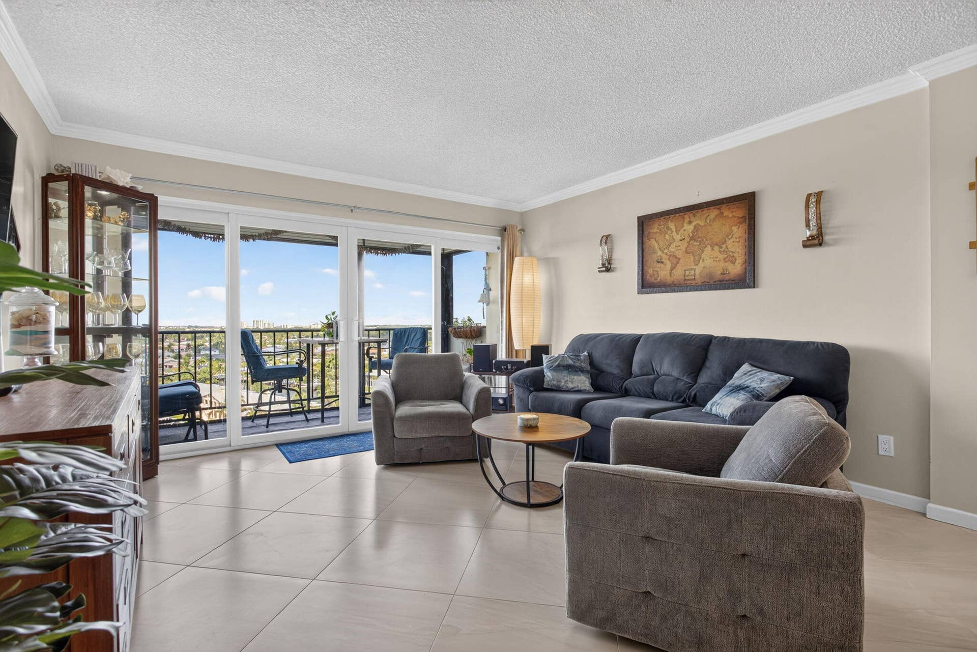 801 S Federal Highway, #1103, Pompano Beach, FL 33062 Neutral tone walls with crown molding, tile flooring, and a sliding glass door to a balcony with black railings