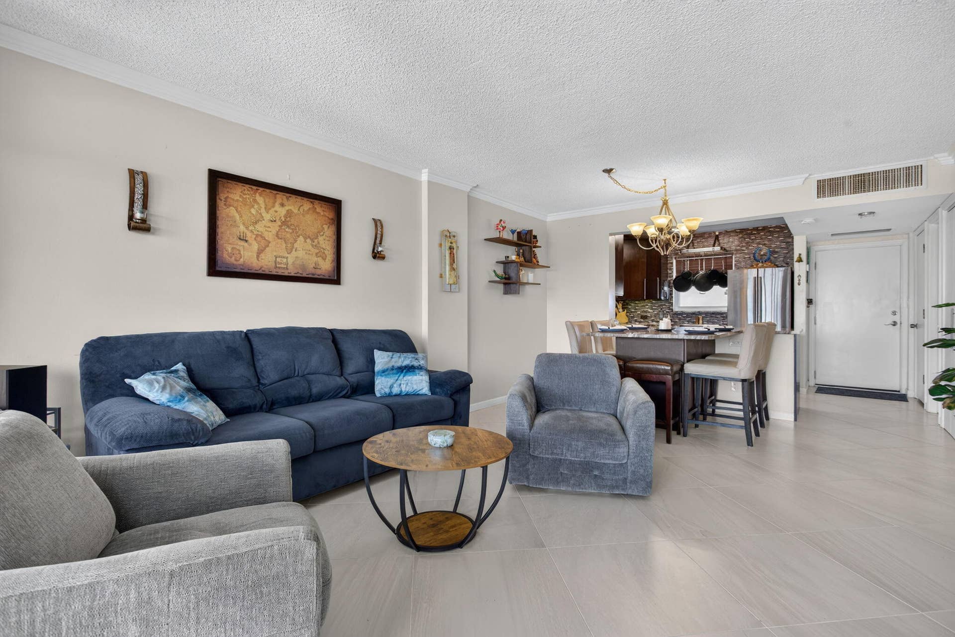 801 S Federal Highway, #1103, Pompano Beach, FL 33062 Light-toned tile flooring, crown molding, built-in shelving, recessed lighting, and a kitchen featuring a breakfast bar with seating