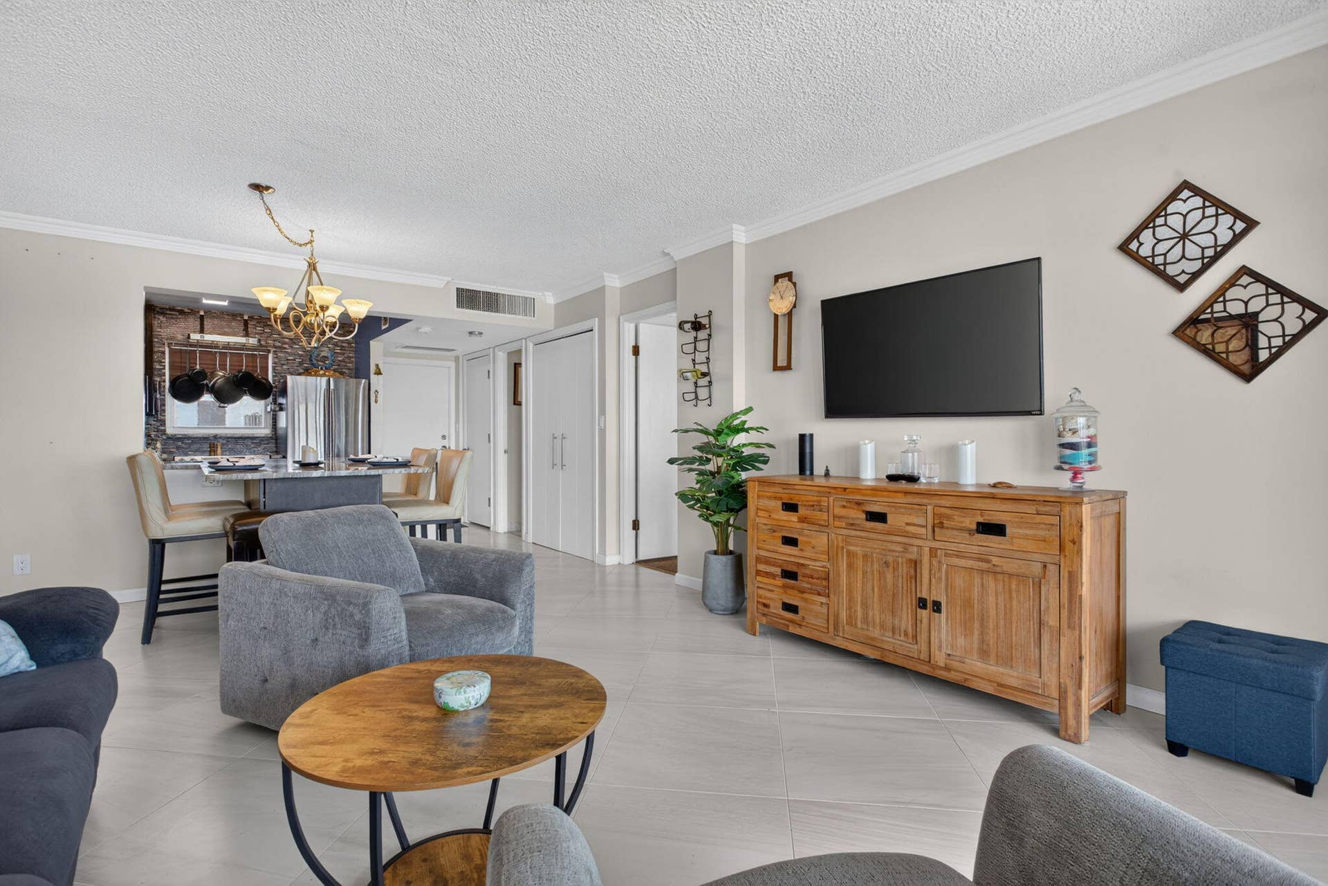 801 S Federal Highway, #1103, Pompano Beach, FL 33062 Recessed ceiling lighting, tiled flooring, crown molding, double bi-fold doors, and a decorative chandelier