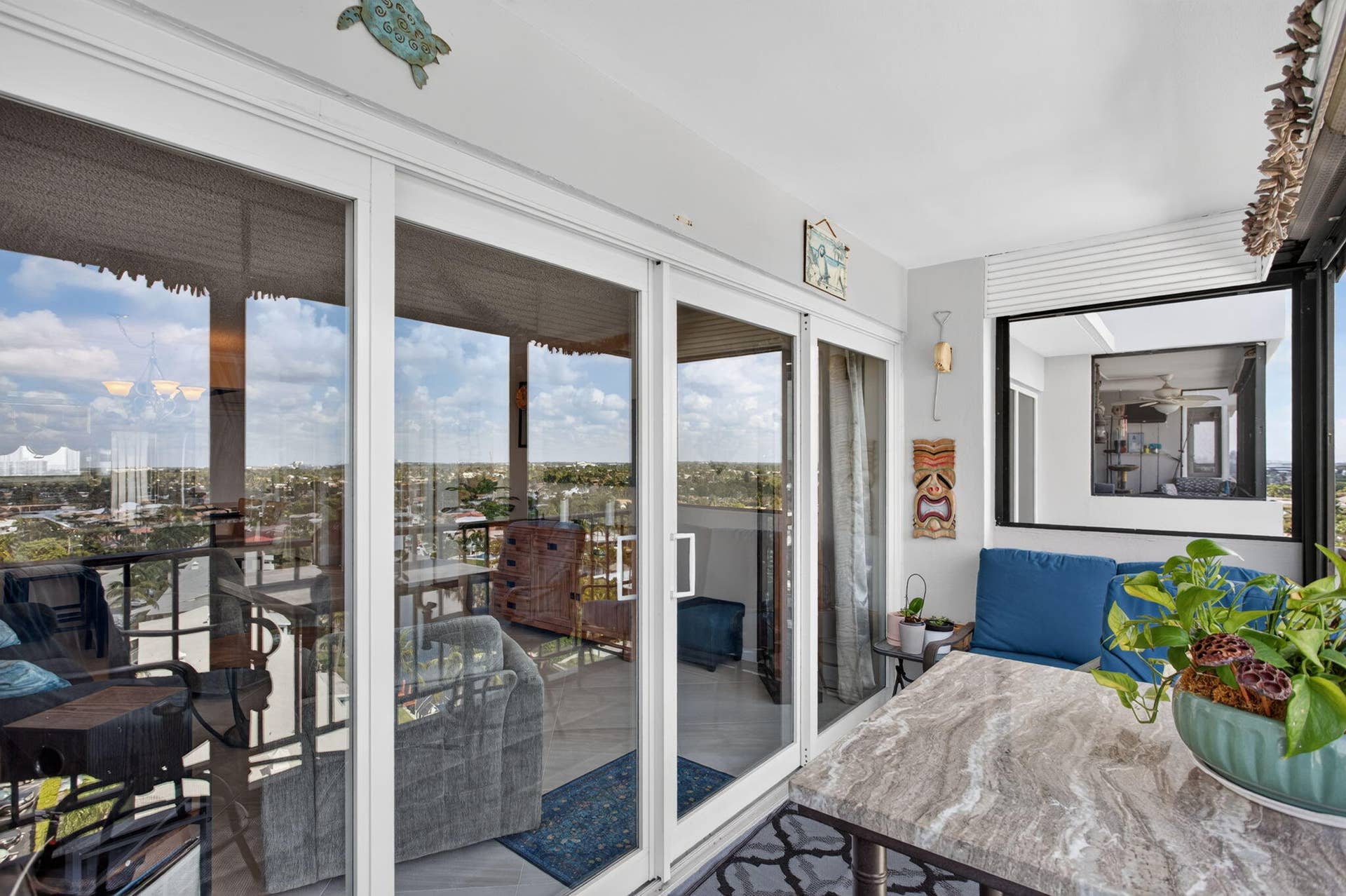 801 S Federal Highway, #1103, Pompano Beach, FL 33062 Screened balcony with sliding glass doors, a stone-top table, and a built-in window opening