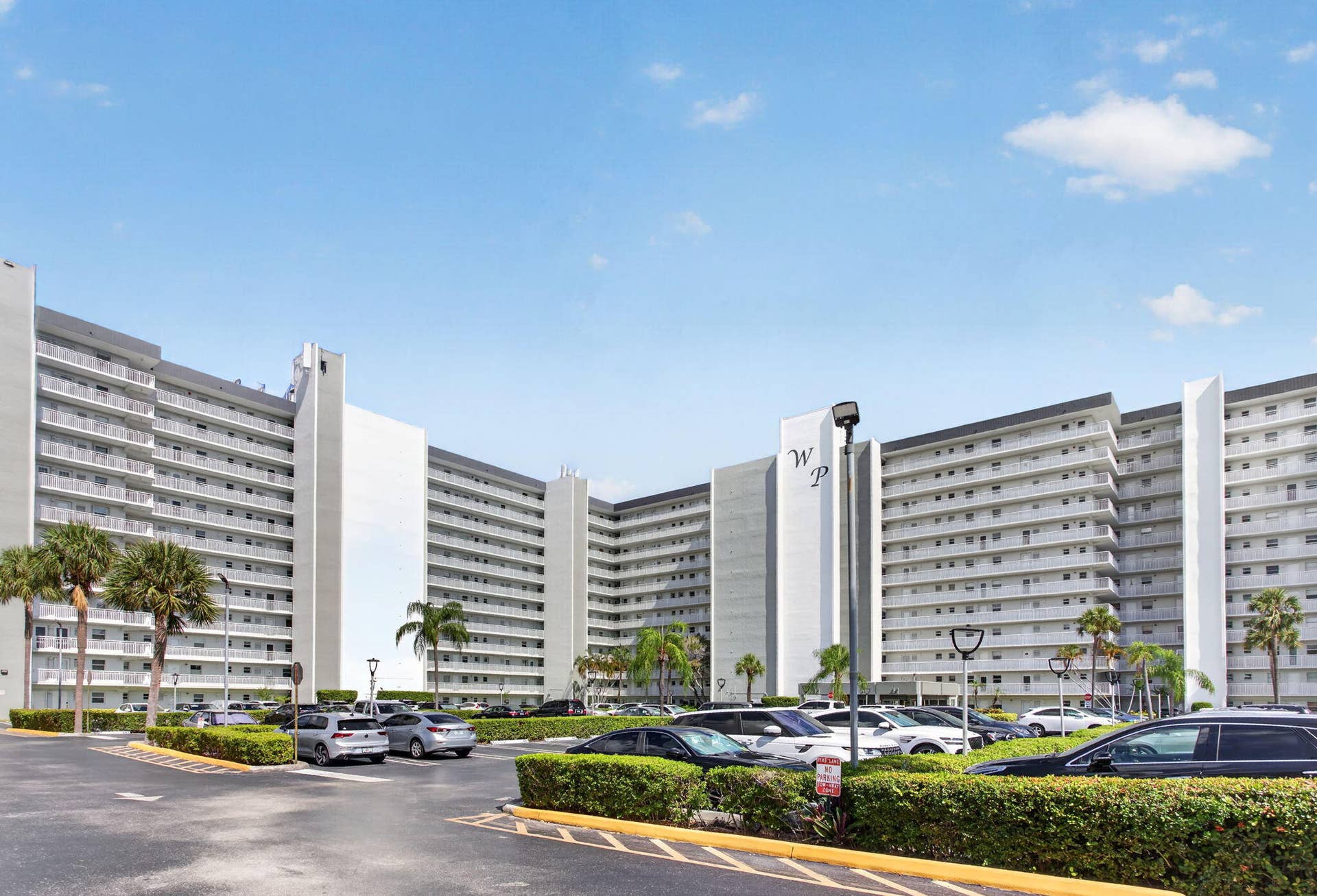 801 S Federal Highway, #1103, Pompano Beach, FL 33062 High-rise building with extensive balconies, multiple levels, and a large parking area with assigned spots.