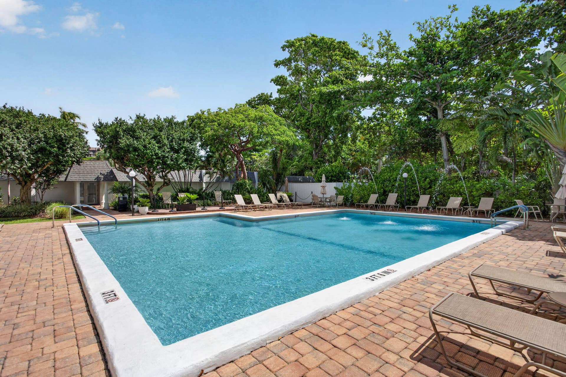 801 S Federal Highway, #1103, Pompano Beach, FL 33062 Swimming pool with water features, surrounded by a brick paver deck and lush landscaping
