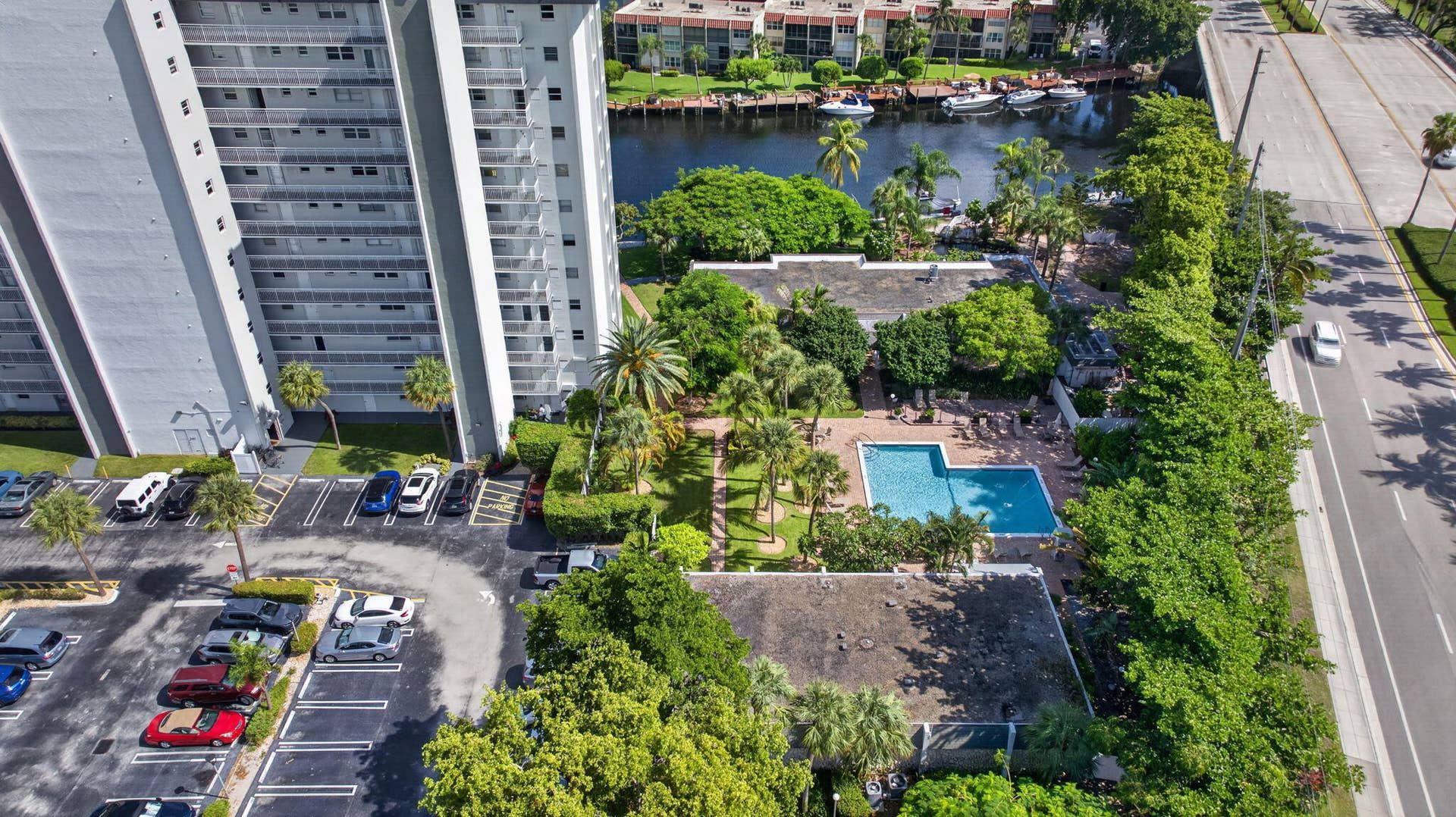 801 S Federal Highway, #1103, Pompano Beach, FL 33062 High-rise building with a private parking lot, outdoor swimming pool, and mature landscaping
