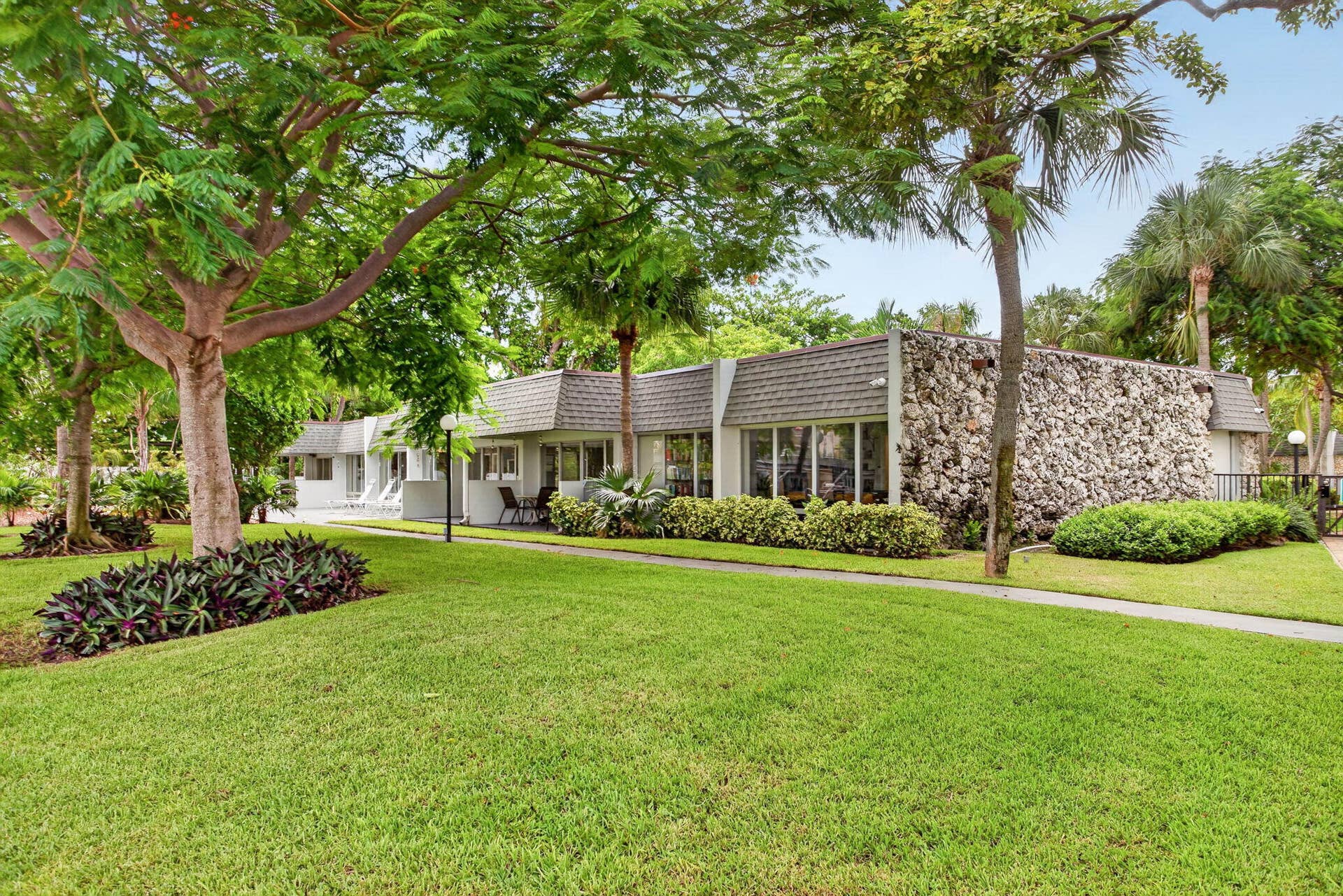 801 S Federal Highway, #1103, Pompano Beach, FL 33062 Exterior with a textured stone wall finish, a sloped roof, and expansive windows