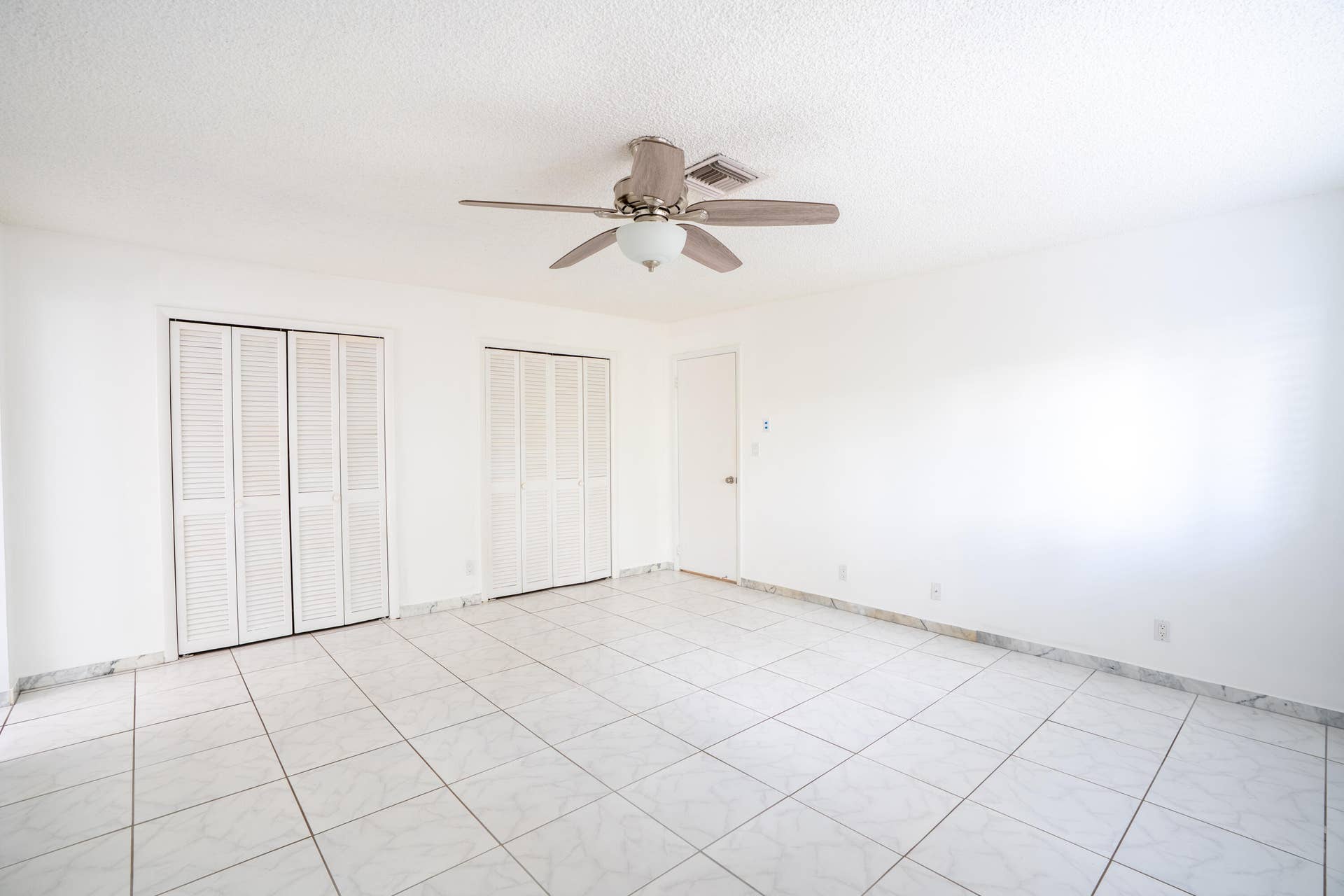 17 SE 8TH Terrace, Deerfield Beach, FL 33441 White tiled flooring, dual louvered bifold closet doors, and ceiling fan with integrated lighting