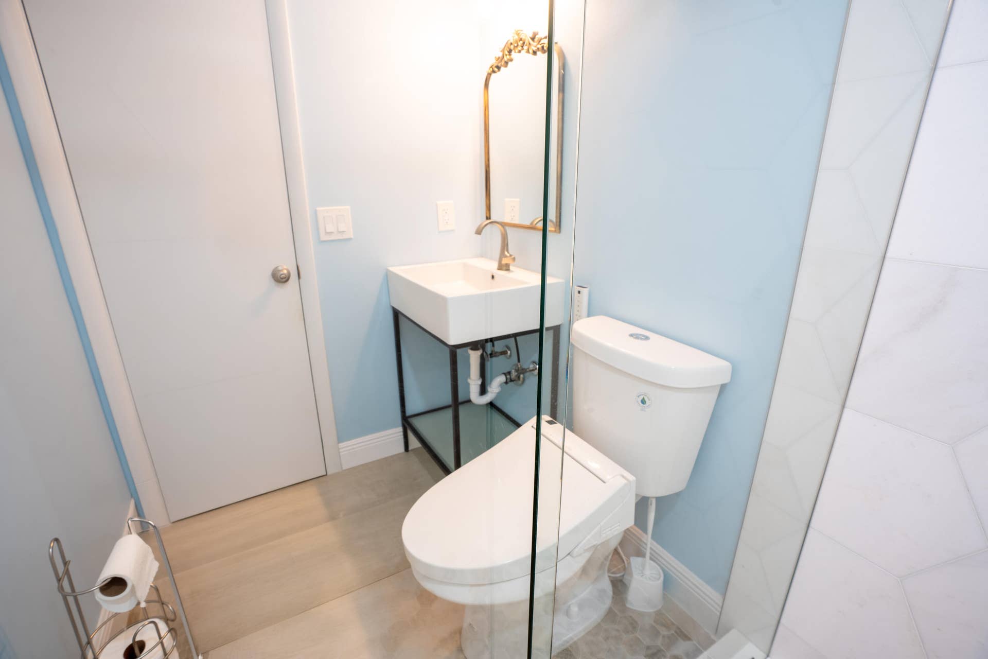 17 SE 8TH Terrace, Deerfield Beach, FL 33441 Wall-mounted vanity with a rectangular basin, gold-tone faucet, and decorative mirror