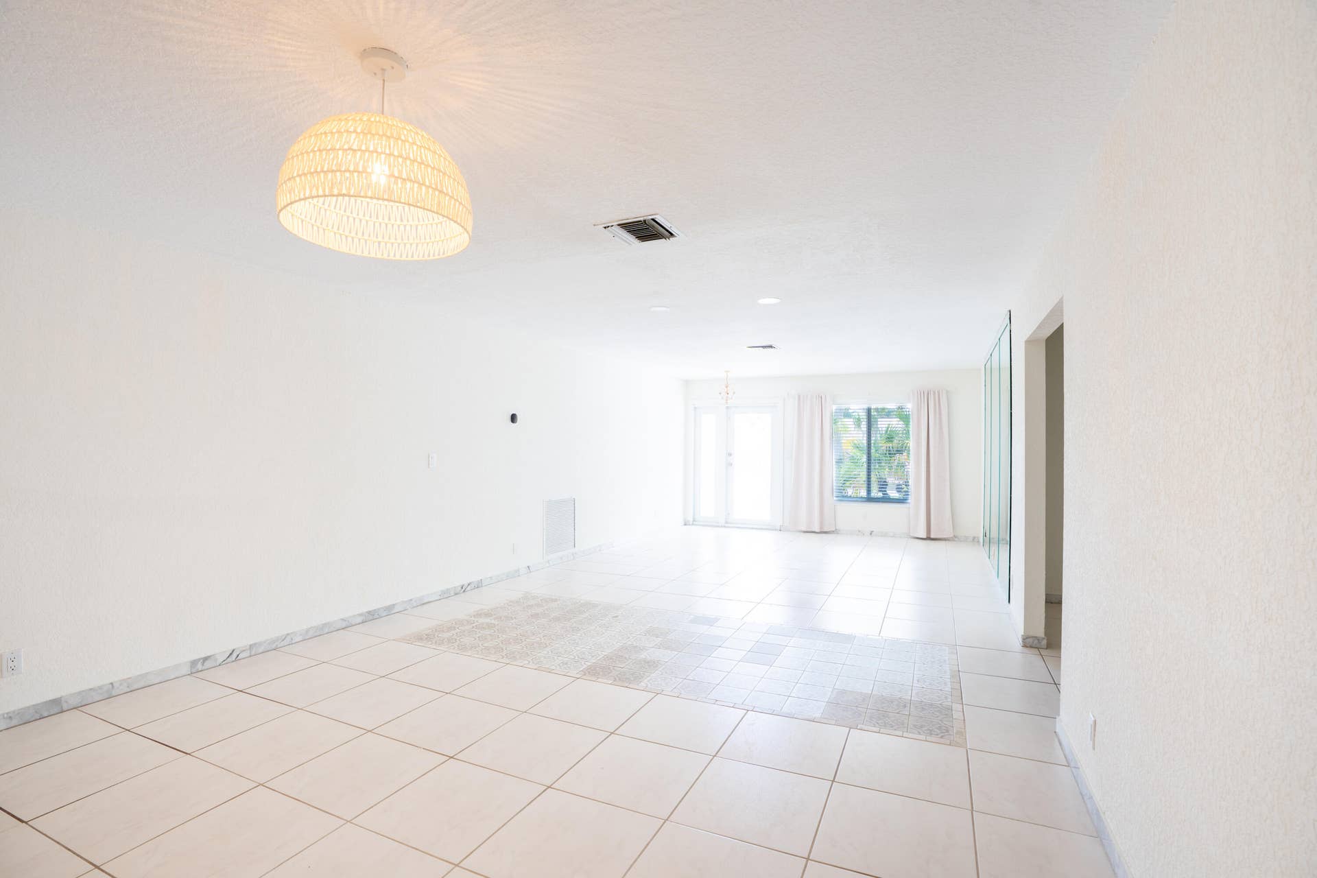 17 SE 8TH Terrace, Deerfield Beach, FL 33441 Expansive interior space featuring tile flooring, white walls, and a woven pendant light fixture