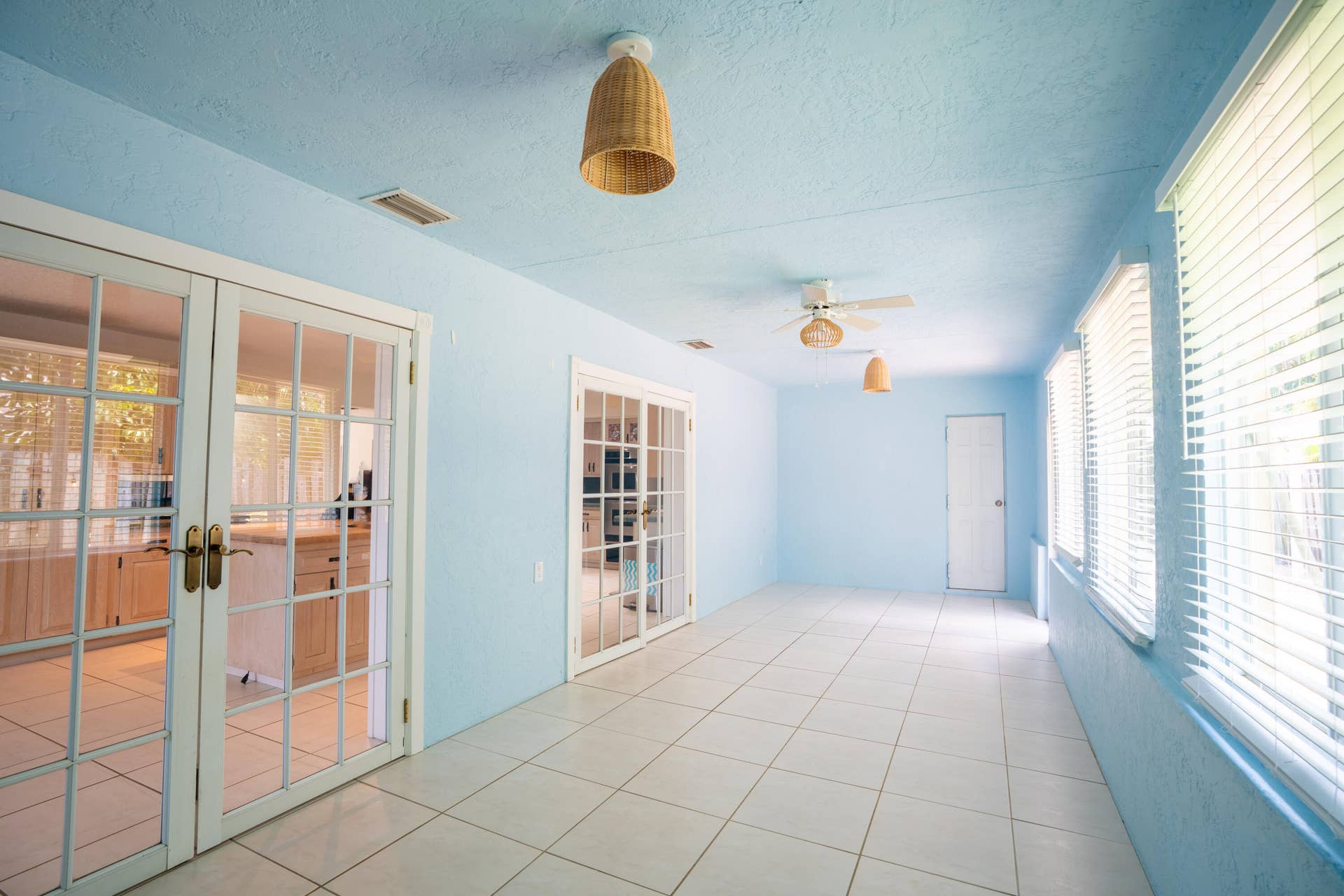 17 SE 8TH Terrace, Deerfield Beach, FL 33441 Expansive room featuring light blue walls, white tile flooring, and multiple glass-paned doors