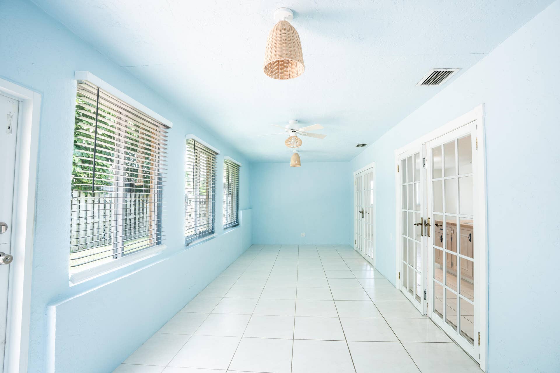 17 SE 8TH Terrace, Deerfield Beach, FL 33441 Long hallway with large windows, white tile flooring, and multiple sets of French doors