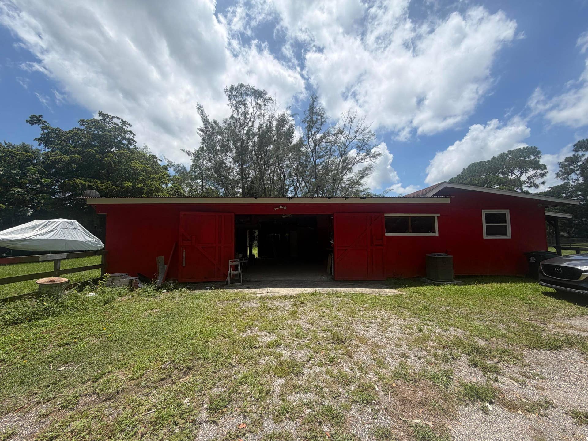 4020 Vinkemulder Road, Coconut Creek, FL 33073 Red exterior building with white window trim and a partial gravel driveway