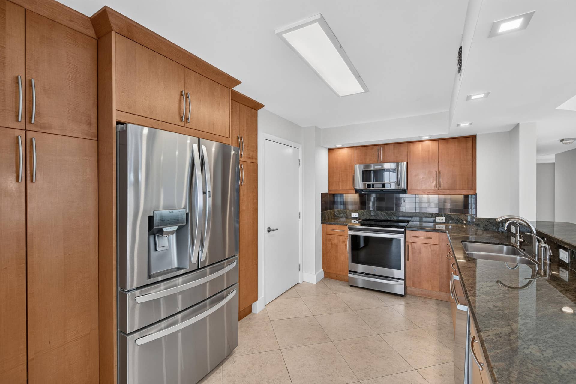 3900 Galt Ocean Drive, #2417, Fort Lauderdale, FL 33308 Warm wood cabinetry, granite countertops and stainless-steel appliances appoint the spacious open kitchen.