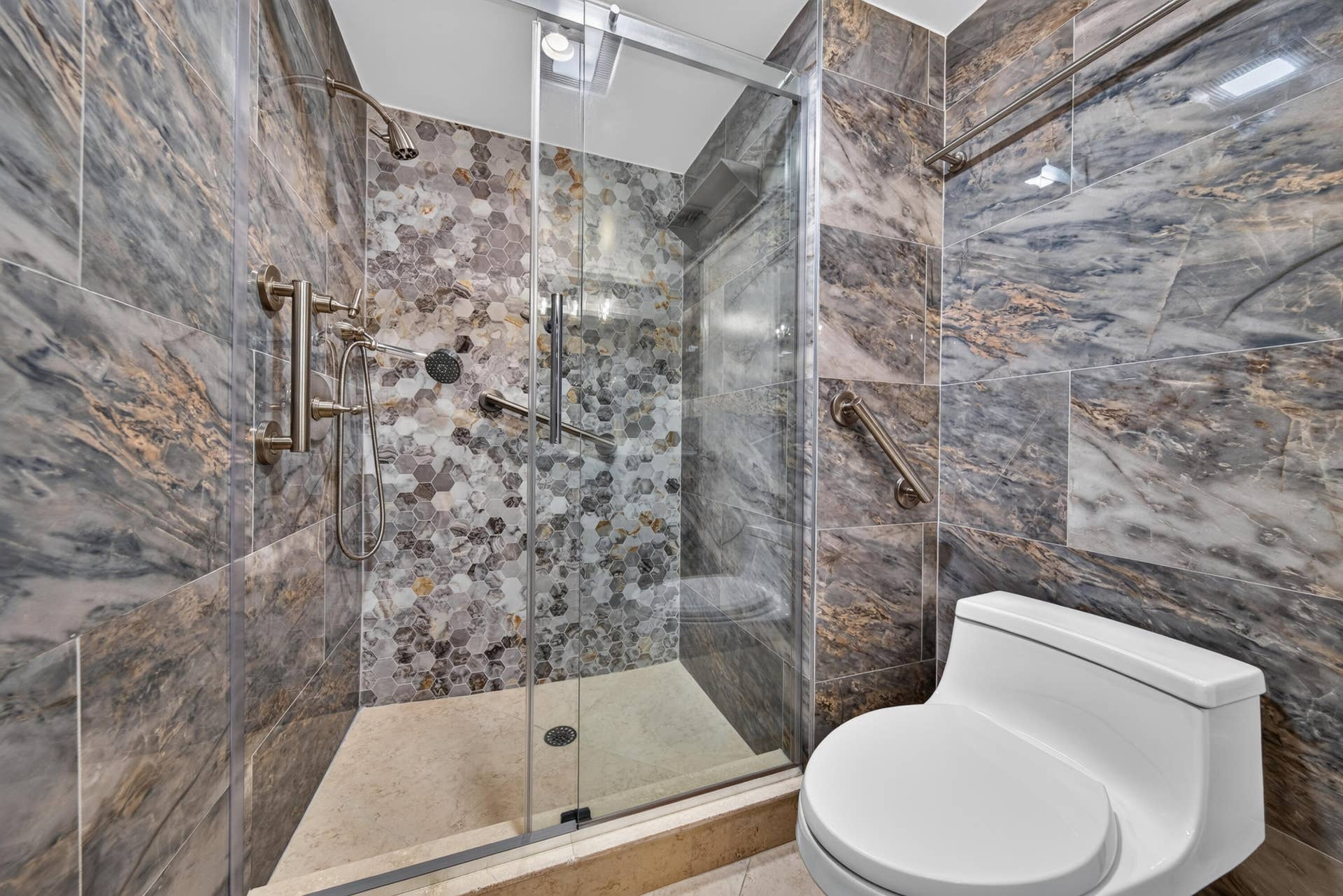 3900 Galt Ocean Drive, #2417, Fort Lauderdale, FL 33308 Updated guest bathroom with a glass-enclosed shower, decorative mosaic tile and handheld shower fixture.