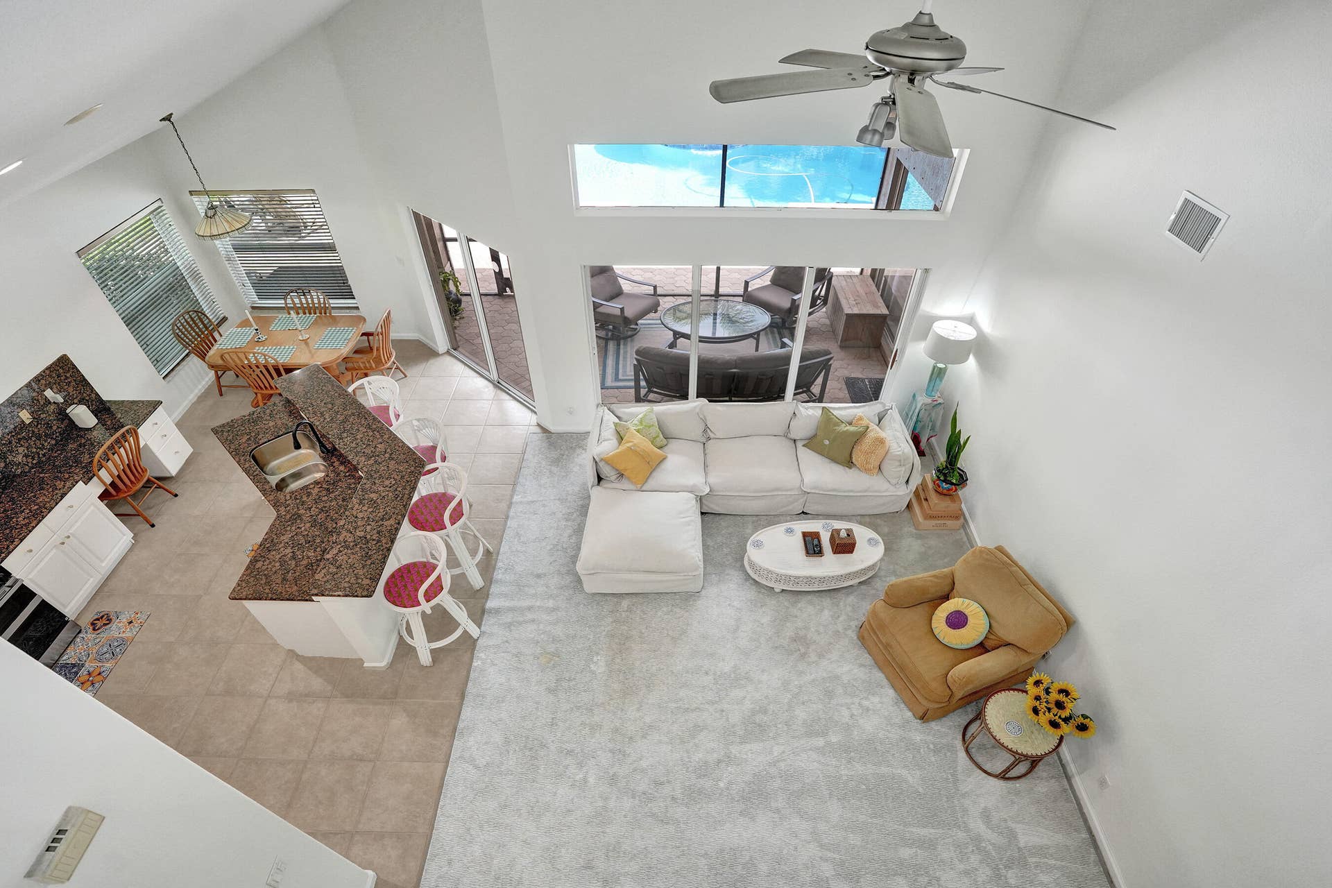 View from loft, Vaulted ceilings, large windows, ceiling fan, and tiled flooring