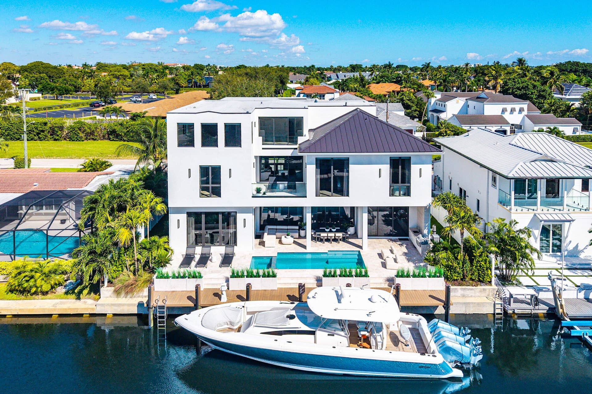 Modern architectural design with multiple balconies, a private pool, and direct water access