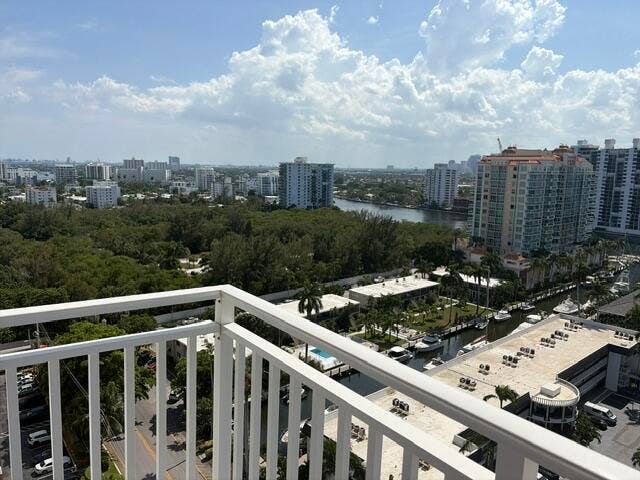 Expansive water and city views from a private balcony with white railings, featuring multiple waterways and residential buildings