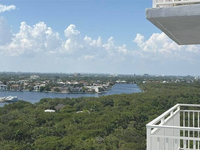 Expansive water and city scape from a balcony with white metal railings