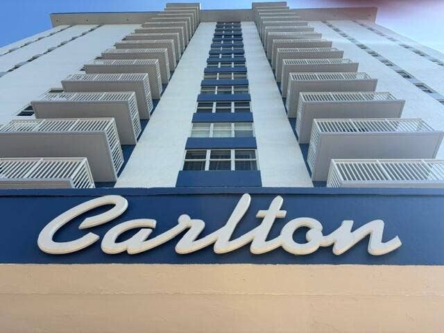 Building exterior featuring multiple balconies with white railings and blue accents