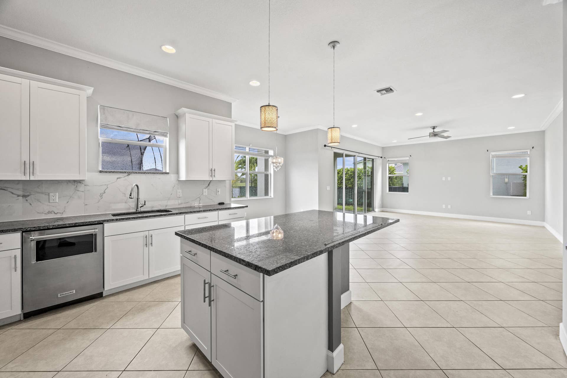 16007 Whippoorwill Circle, Westlake, Westlake, FL 33470 Spacious kitchen featuring white cabinetry, granite countertops, and a full-height backsplash