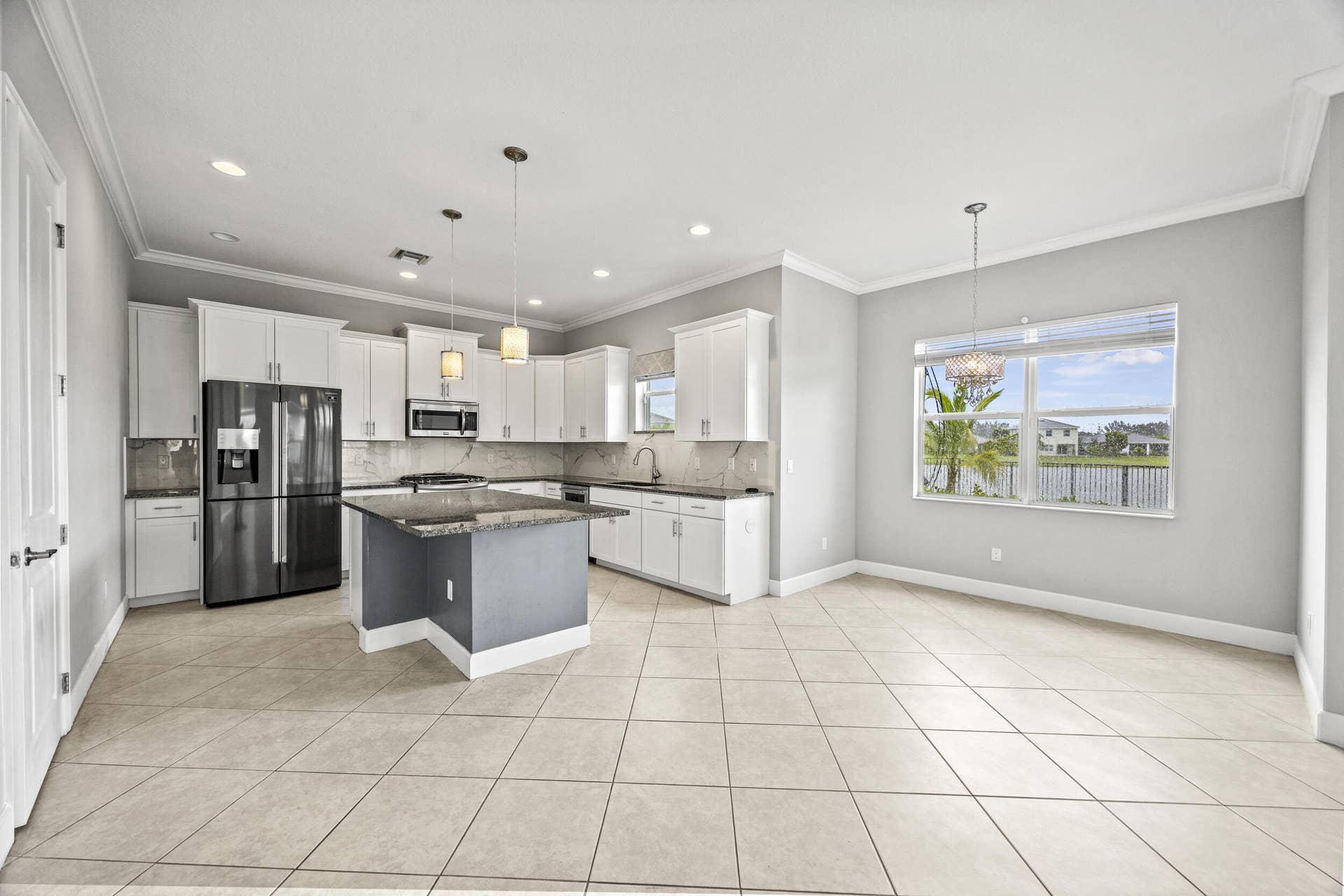 16007 Whippoorwill Circle, Westlake, Westlake, FL 33470 Expansive kitchen with white cabinetry, a center island with a stone countertop, a stainless steel appliance suite, and tile flooring