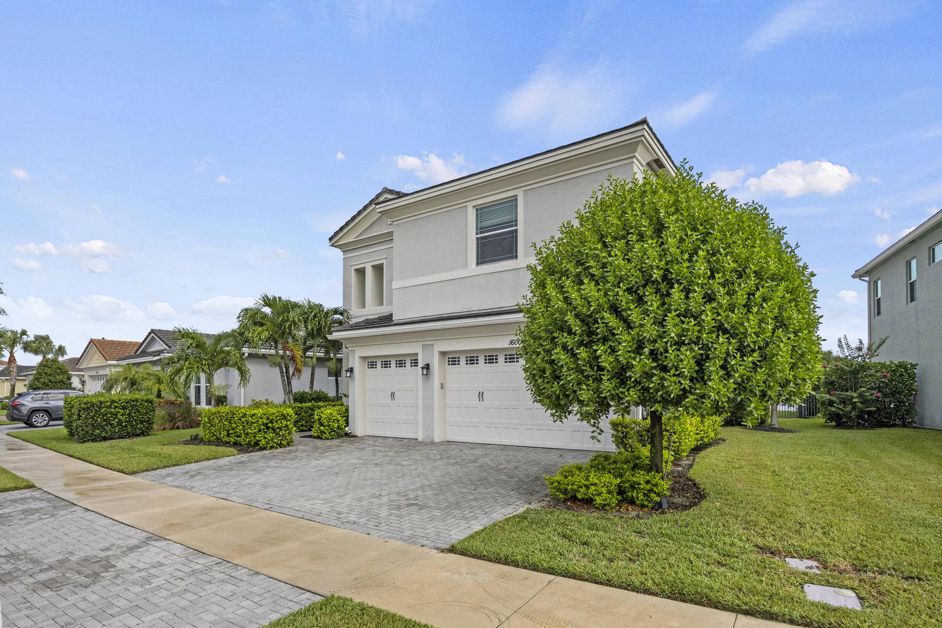 16007 Whippoorwill Circle, Westlake, Westlake, FL 33470 Two-story exterior with a two-car garage, paver driveway, and mature landscaping