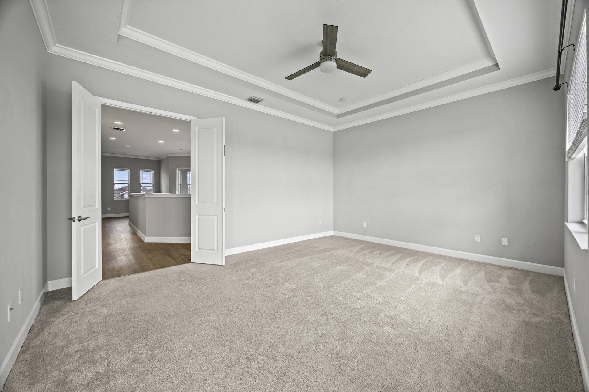 16007 Whippoorwill Circle, Westlake, Westlake, FL 33470 Tray ceiling with crown molding, carpeted flooring, double doors, ceiling fan, and window