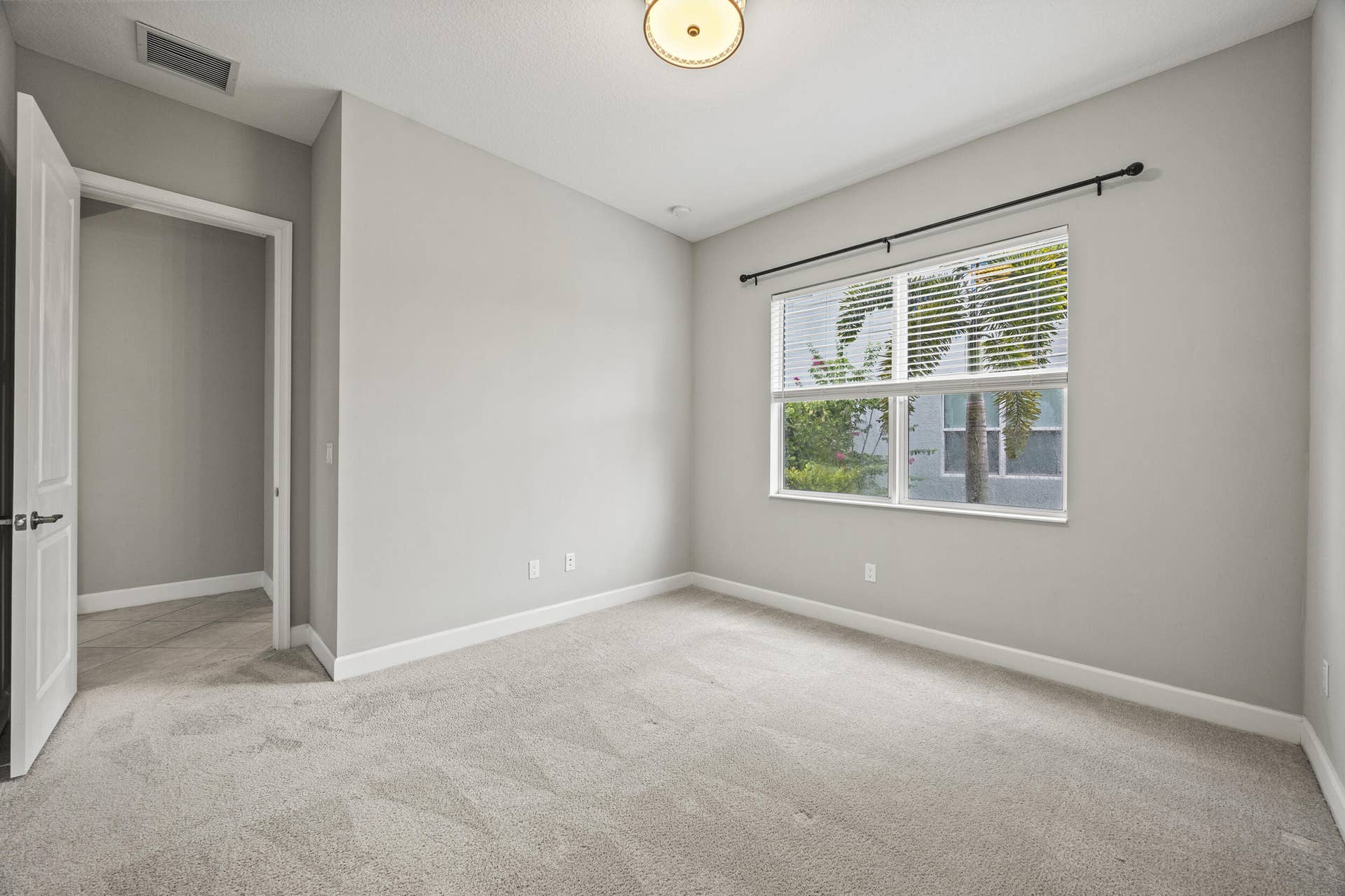 16007 Whippoorwill Circle, Westlake, Westlake, FL 33470 Neutral wall paint, carpet flooring, a window with horizontal blinds, and a flush mount ceiling light