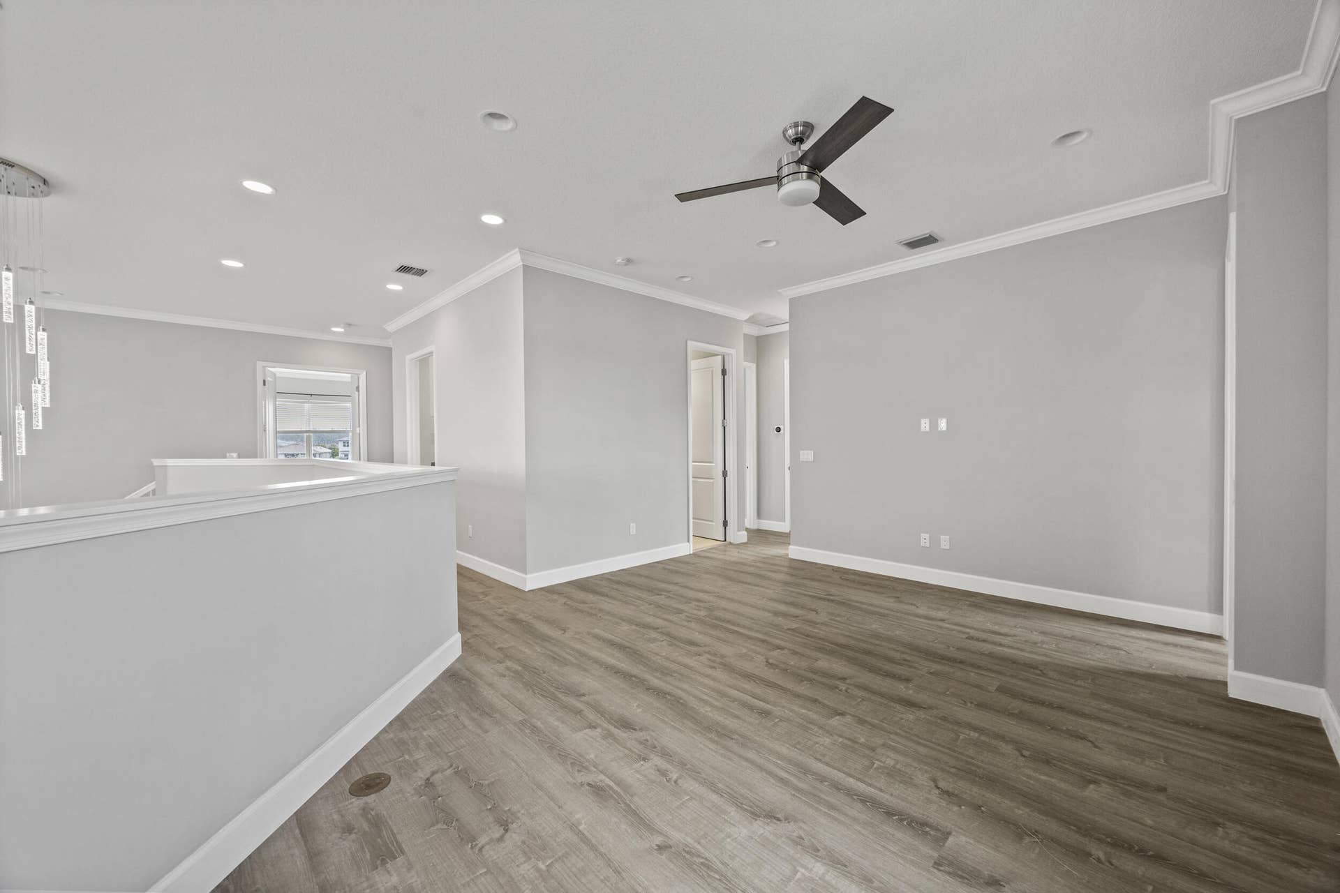 16007 Whippoorwill Circle, Westlake, Westlake, FL 33470 Wood-finish flooring, recessed lighting, ceiling fan, crown molding, and a contemporary chandelier
